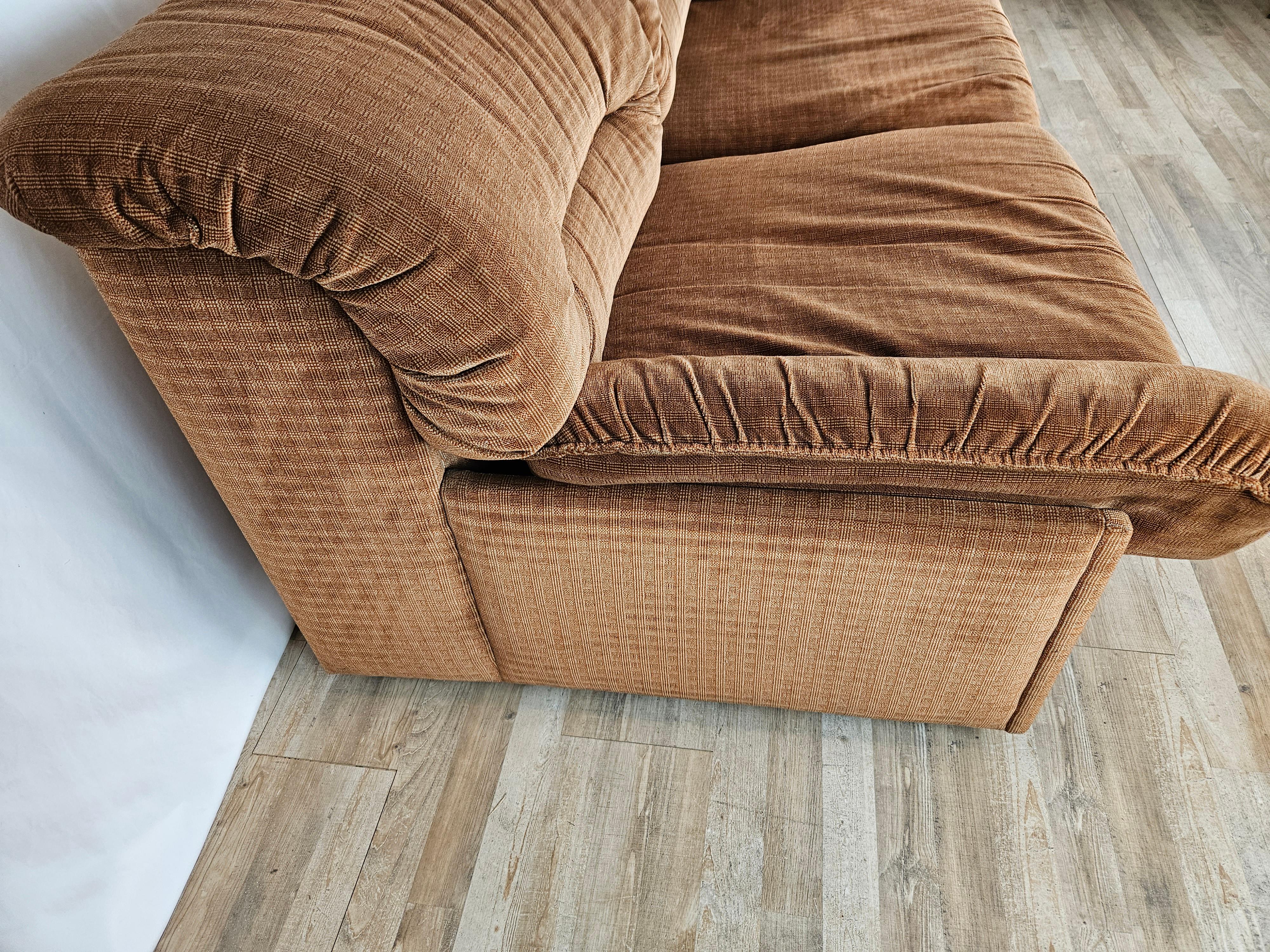 Bequemes Zweisitzer-Sofa, ca. 1970er Jahre, italienische Produktion von Doimo, wie die Markierungen unter den Polstern zeigen.

Das Sofa ist gepolstert und mit hellbraunem Stoff bezogen und hat zwei Kissen auf dem Sitz mit Seitenlehnen.

Der
