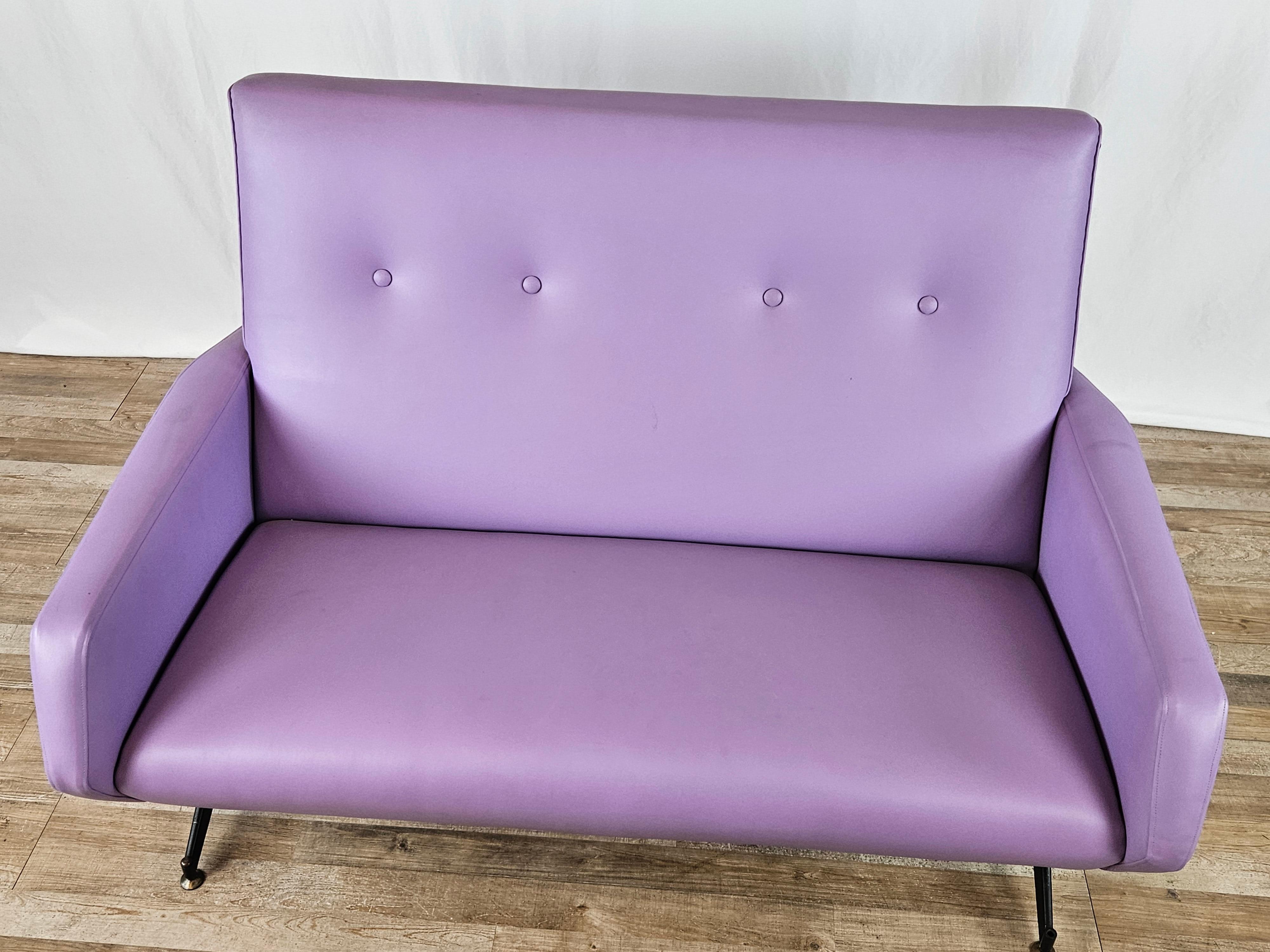 Modern two-seater sofa made of lilac-colored skai (leatherette) and iron frame with height-adjustable feet.

Vibrant and modern color, adaptable anywhere.

Despite its age it has been kept in very good condition, has two small holes at the sides as