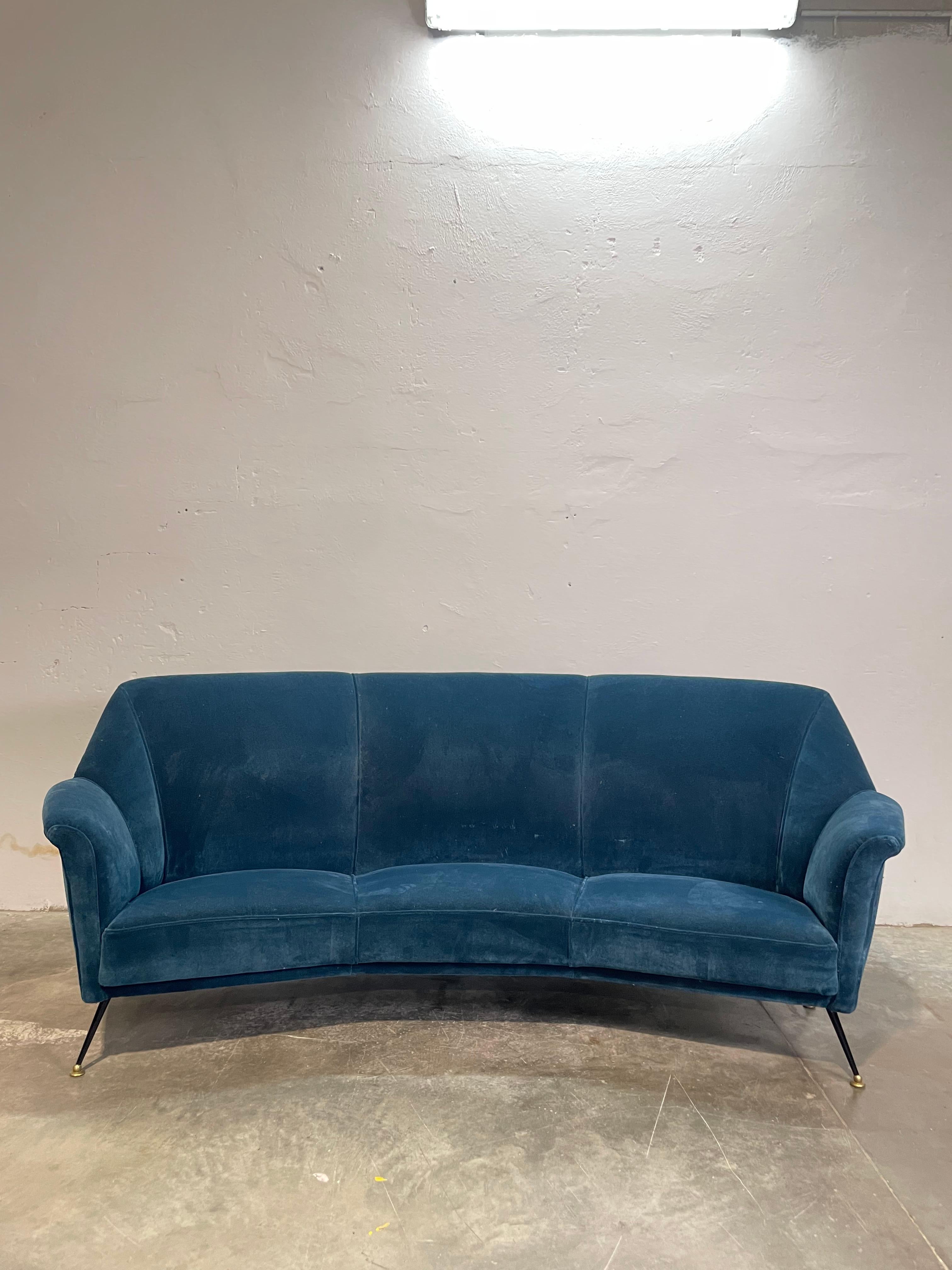 Elegante divano in velluto blu, ispirato allo stile iconico di Ico Parisi, design simbolo degli anni '70. Usato pochissimo, in condizioni eccellenti, questo pezzo incarna la raffinatezza e la modernità del design italiano. Le linee fluide e