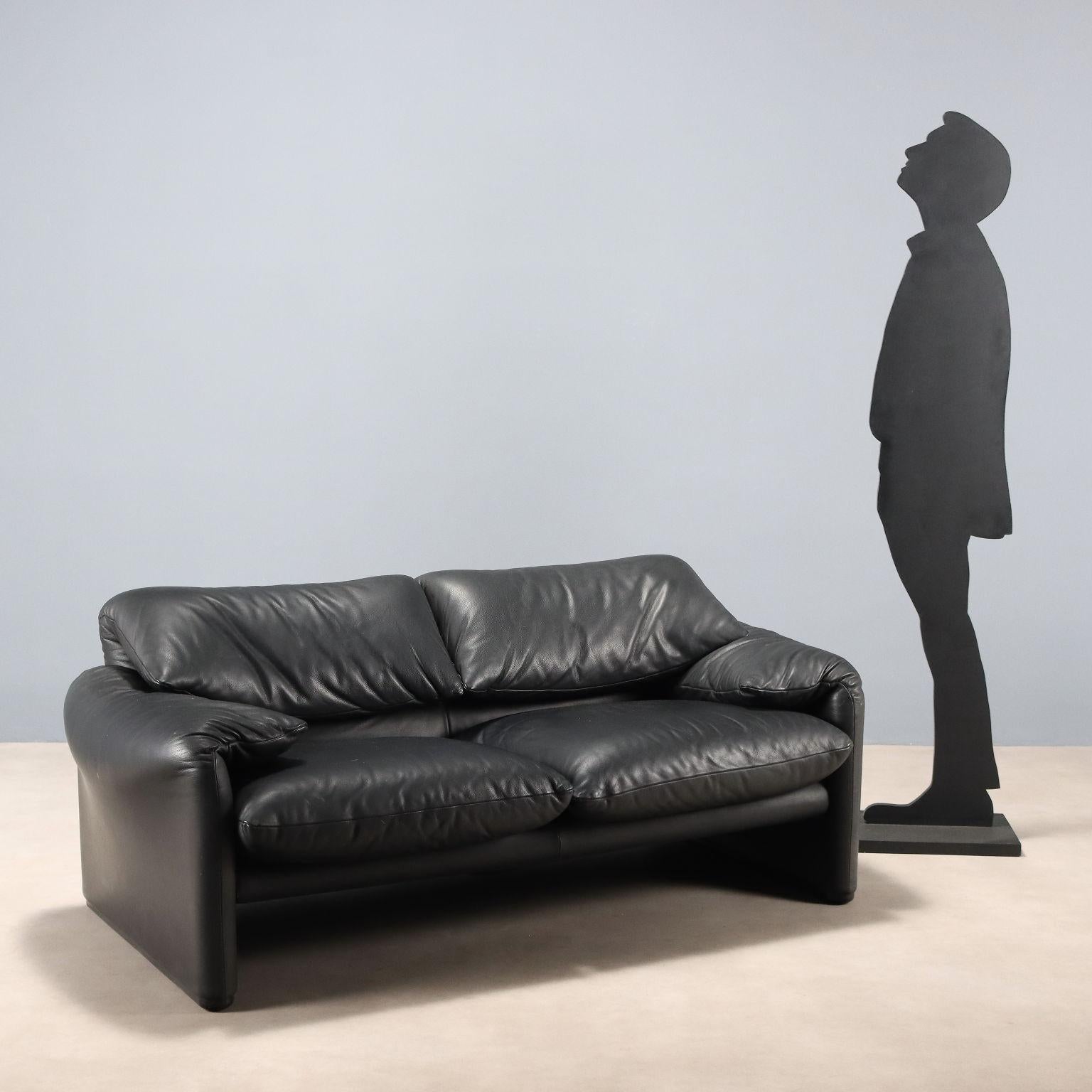 Divano due posti con imbottitura in espanso e rivestimento in pelle nera dotato di schienale con poggiatesta ribaltabile. En bonnes conditions générales, avec l'étiquette de la manifestation.