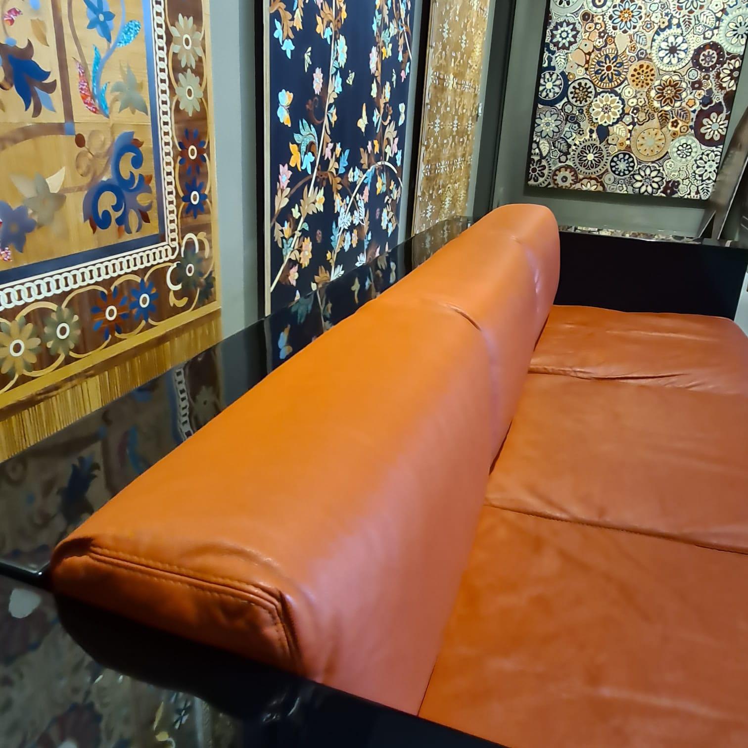 Saratoga è il divano disegnato nel 1964 da Lella & Massimo Vignelli per Poltronova con struttura in legno laccato al poliestere lucido nero e cuscini sfoderabili di piuma rivestiti in pelle cognac. La struttura rigida, realizzata mediante