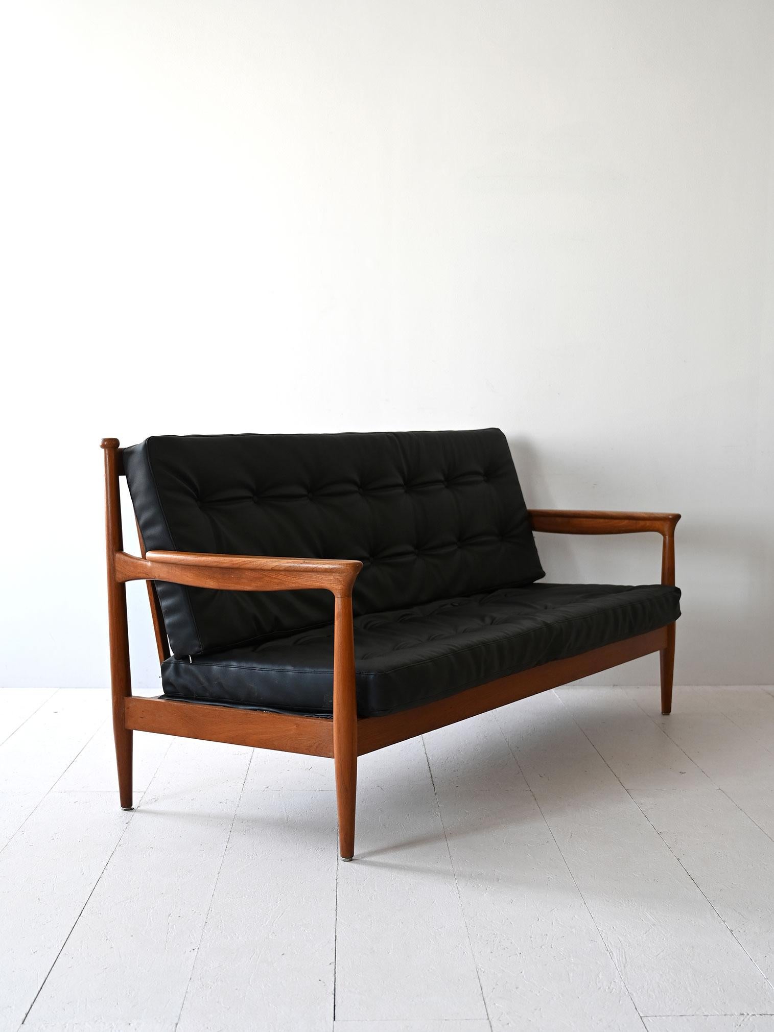 Original sofá escandinavo con armazón y reposabrazos de madera de abedul. El respaldo y el asiento tienen cojines tapizados en polipiel negra. 

El diseño minimalista y las líneas elegantes son típicos del estilo nórdico del siglo XX. Buen estado.