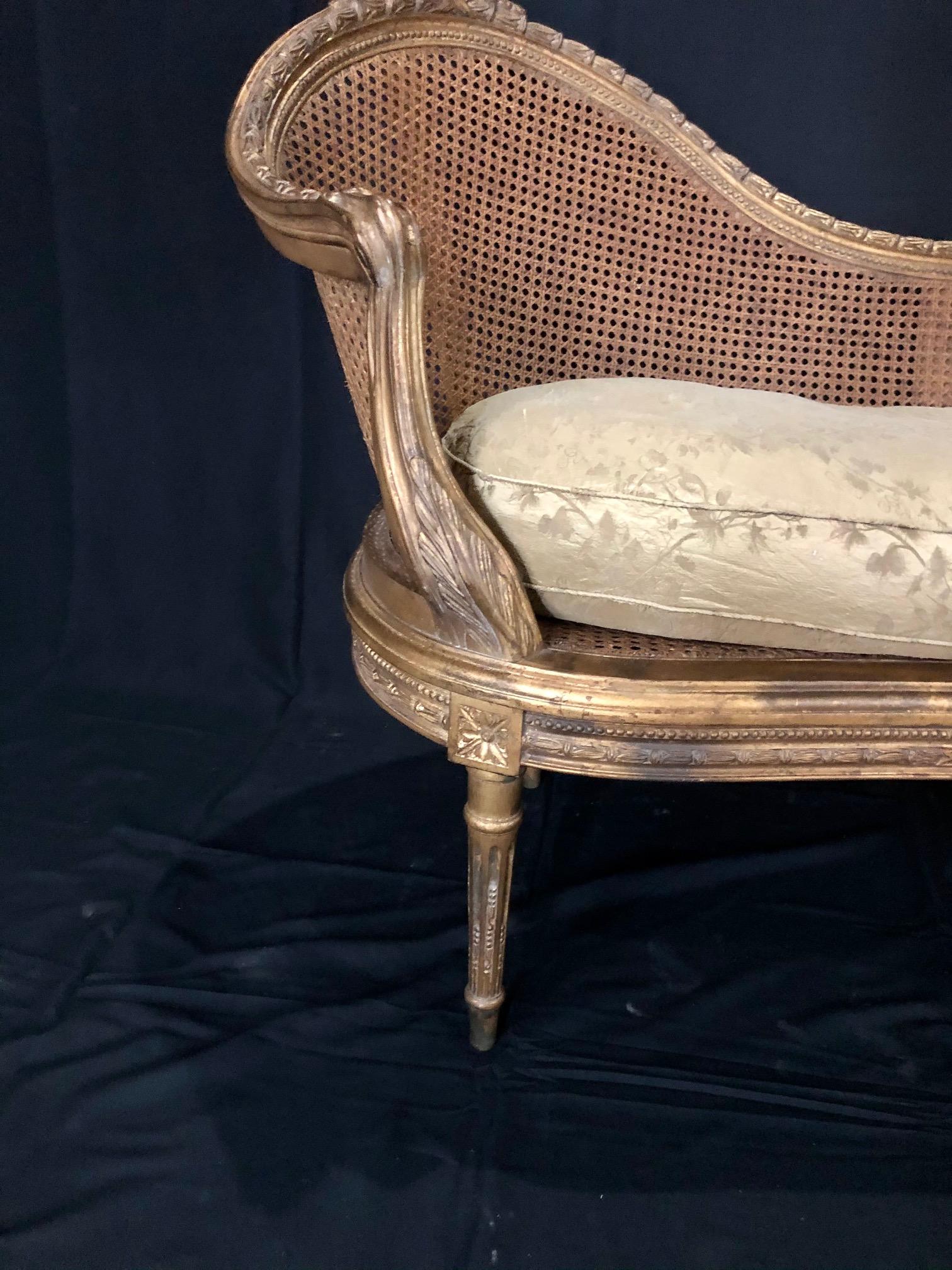 Beautiful curved back French Louis XV style gold gilt caned loveseat settee with immaculate caning and original separate down cushion. #5074
 
Measure: H seat 15-23” (without/with cushion).