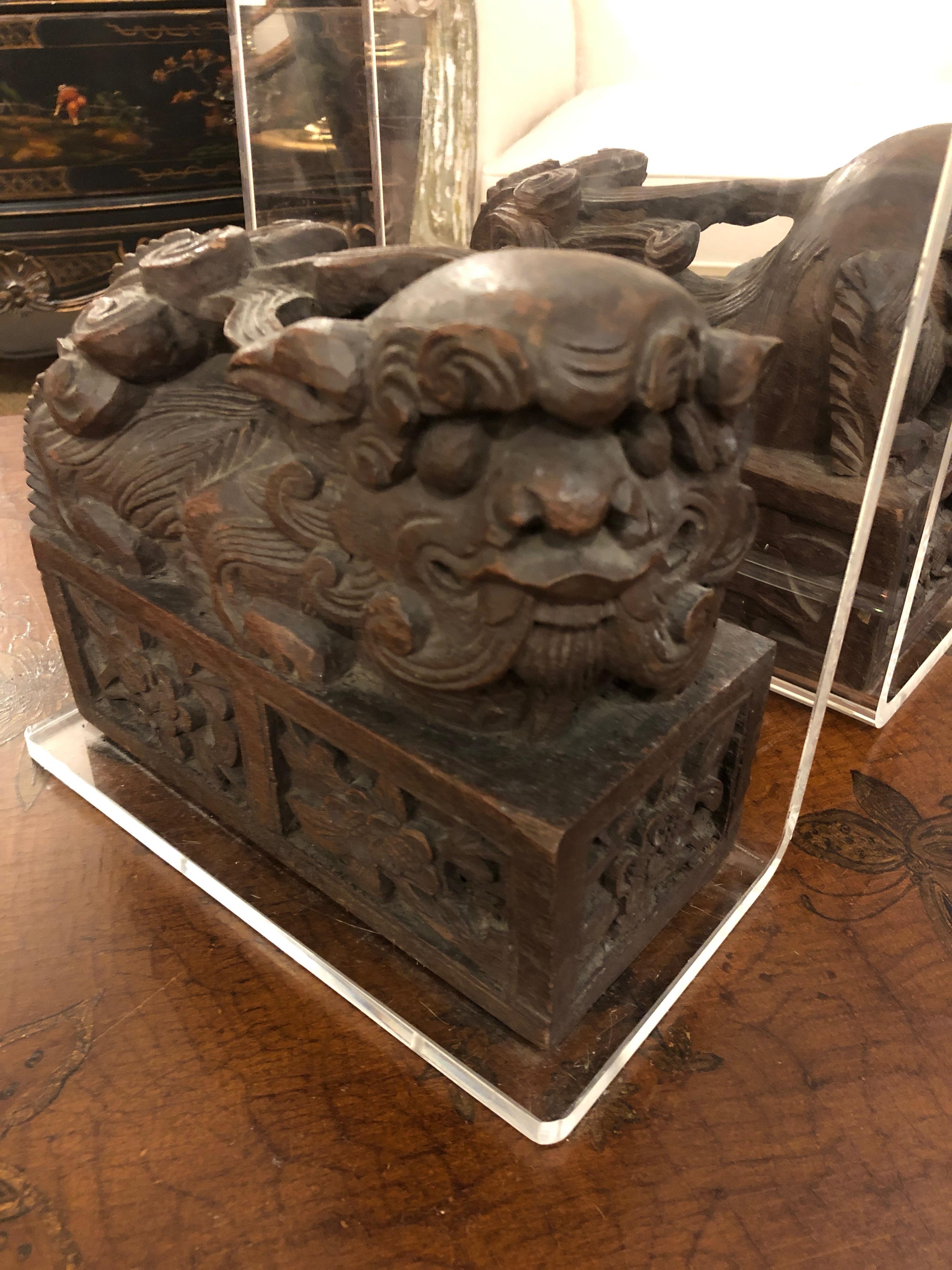 A wonderful set of Asian foo dog bookends constructed of hand carved antique sculptures mounted on Lucite forms. A stylish combination of old and modern.