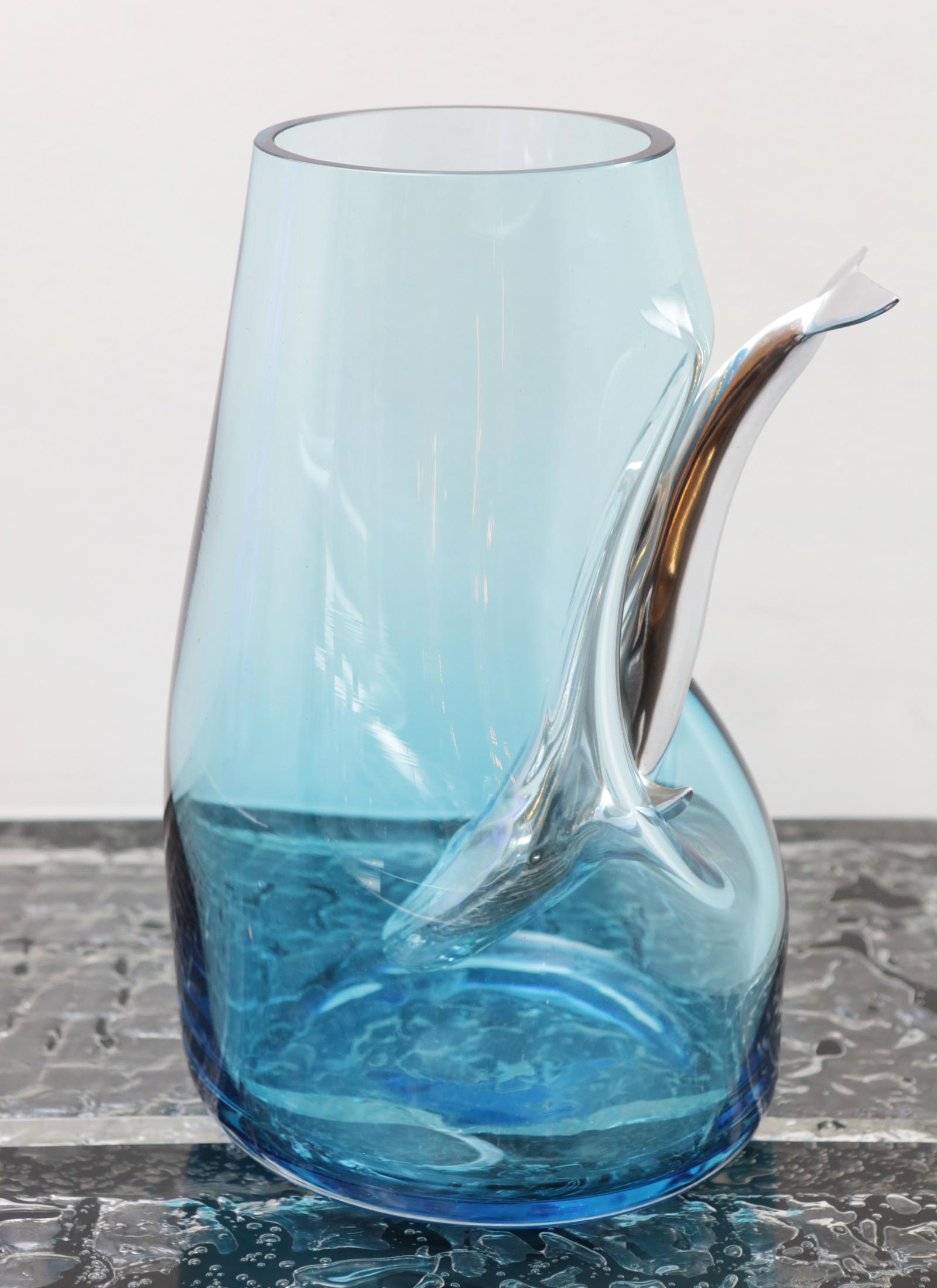 Vase diving whale blue made in handblown blue
glass with a diving whale in polished aluminium through
the glass.
 