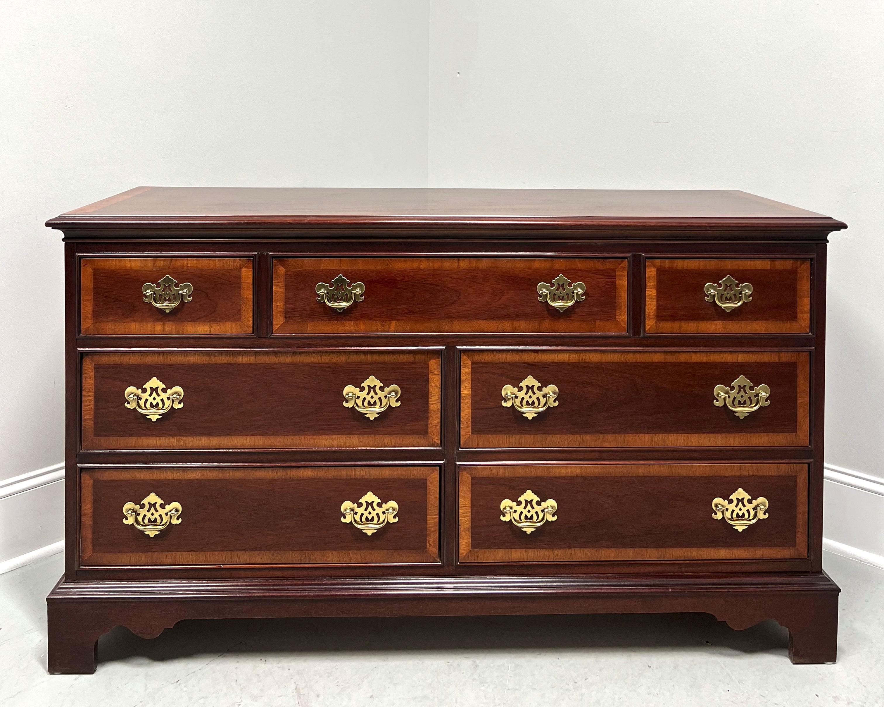 A Chippendale style triple dresser by Dixie Furniture. Mahogany with brass hardware, banded inlaid top with ogee edge, banded drawer fronts, and bracket feet. Features three smaller over four larger drawers of dovetail construction. Made in Lenoir,