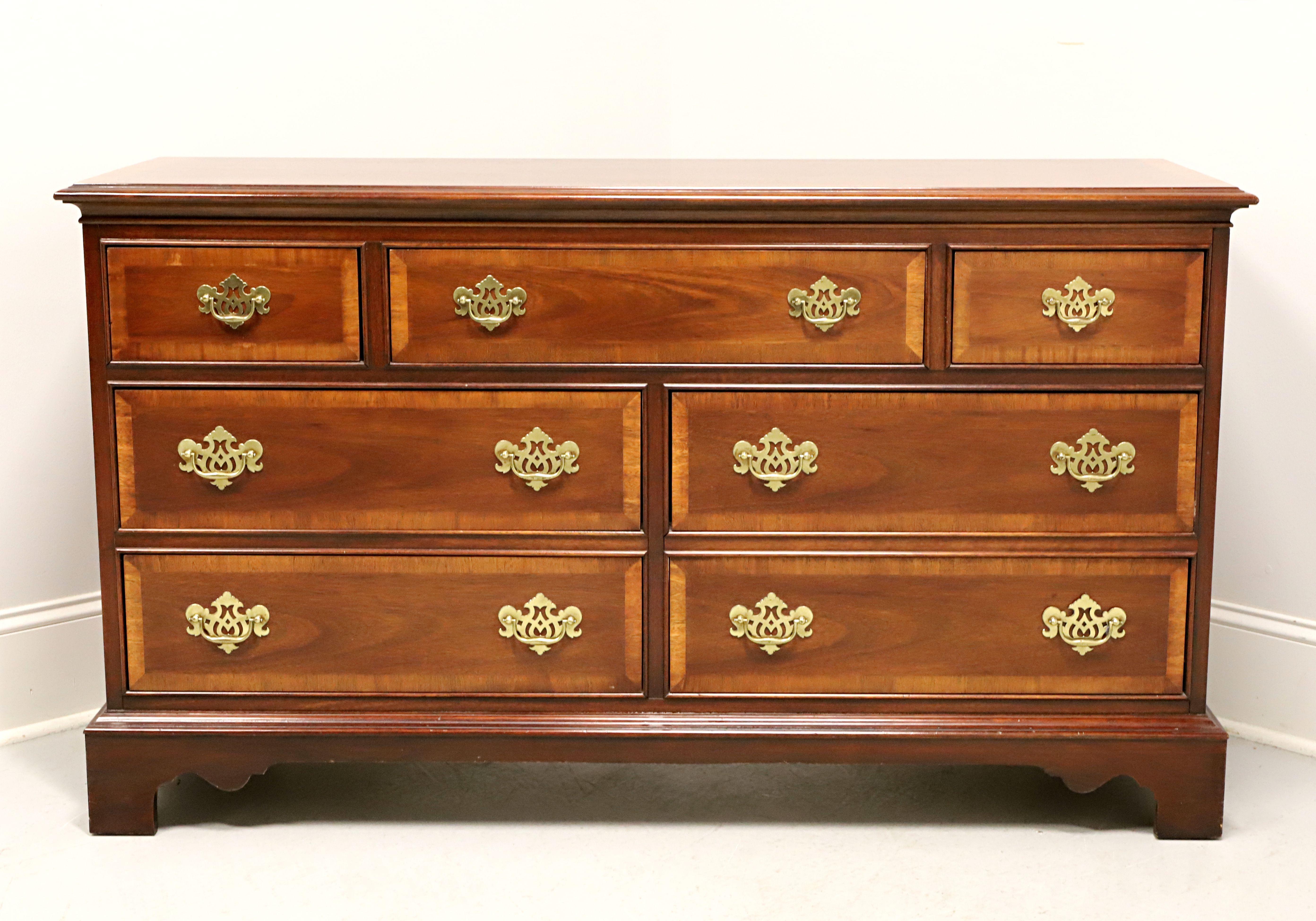 A Chippendale style triple dresser by Dixie Furniture. Mahogany with brass hardware, banded inlaid top with bevel edge, banded drawer fronts, and bracket feet. Features three smaller over four larger drawers of dovetail construction. Made in Lenoir,