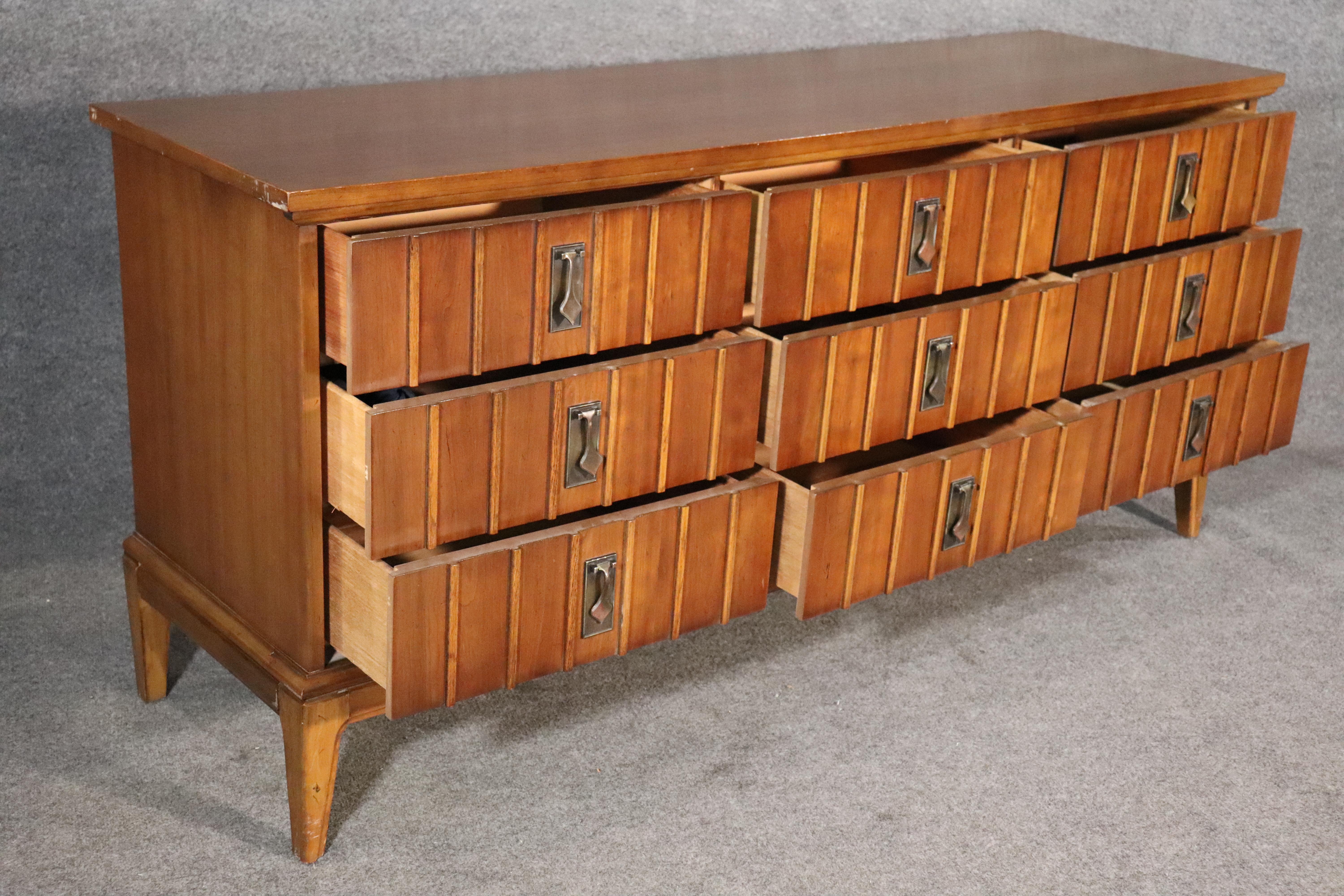 Mid-Century Modern long chest of drawers by Dixie Furniture. All walnut grain with metal spade handles.