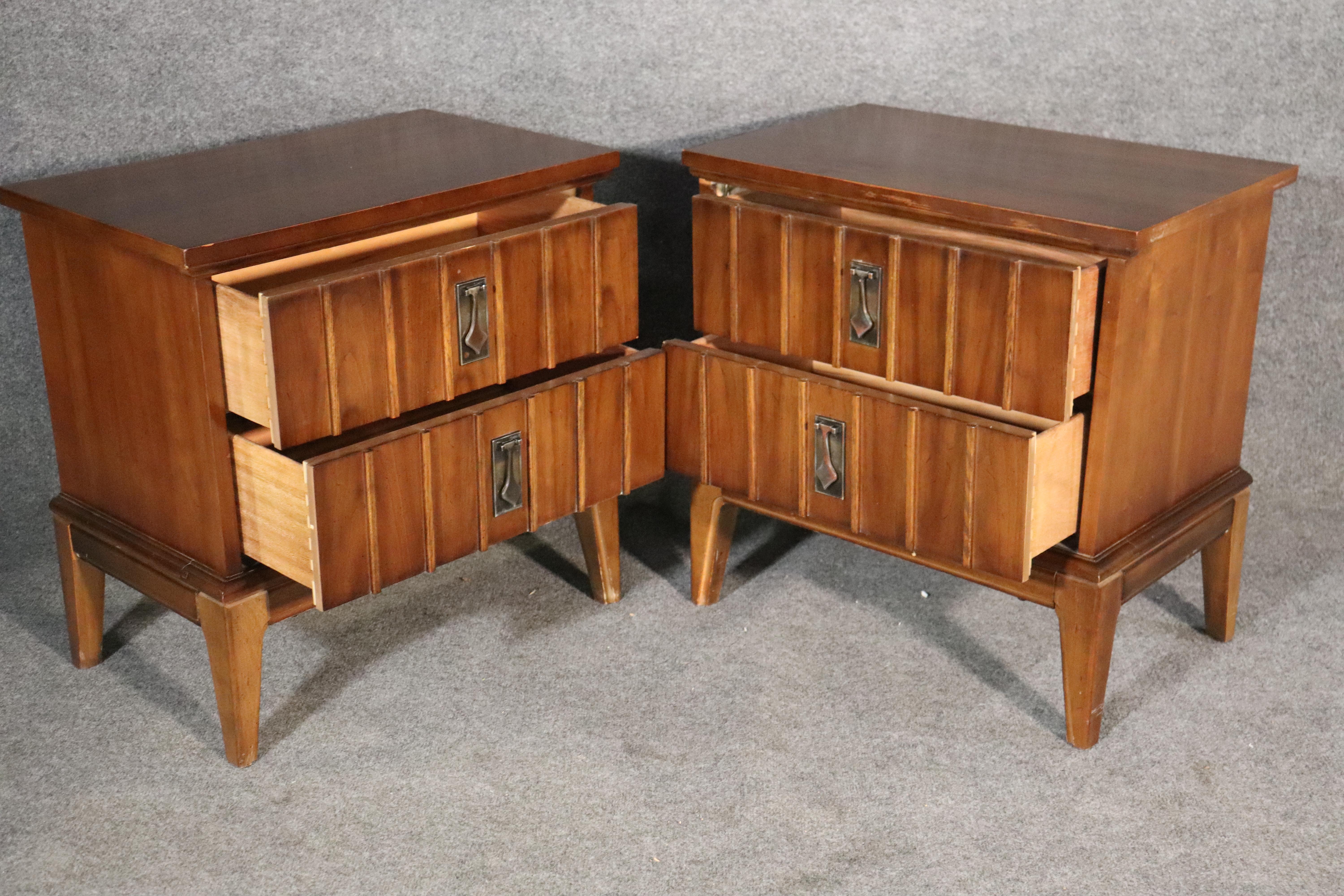 Pair of walnut wood nightstands by Dixie Furniture. Features their metal spade handles and textured front.
Please confirm location NY or NJ.