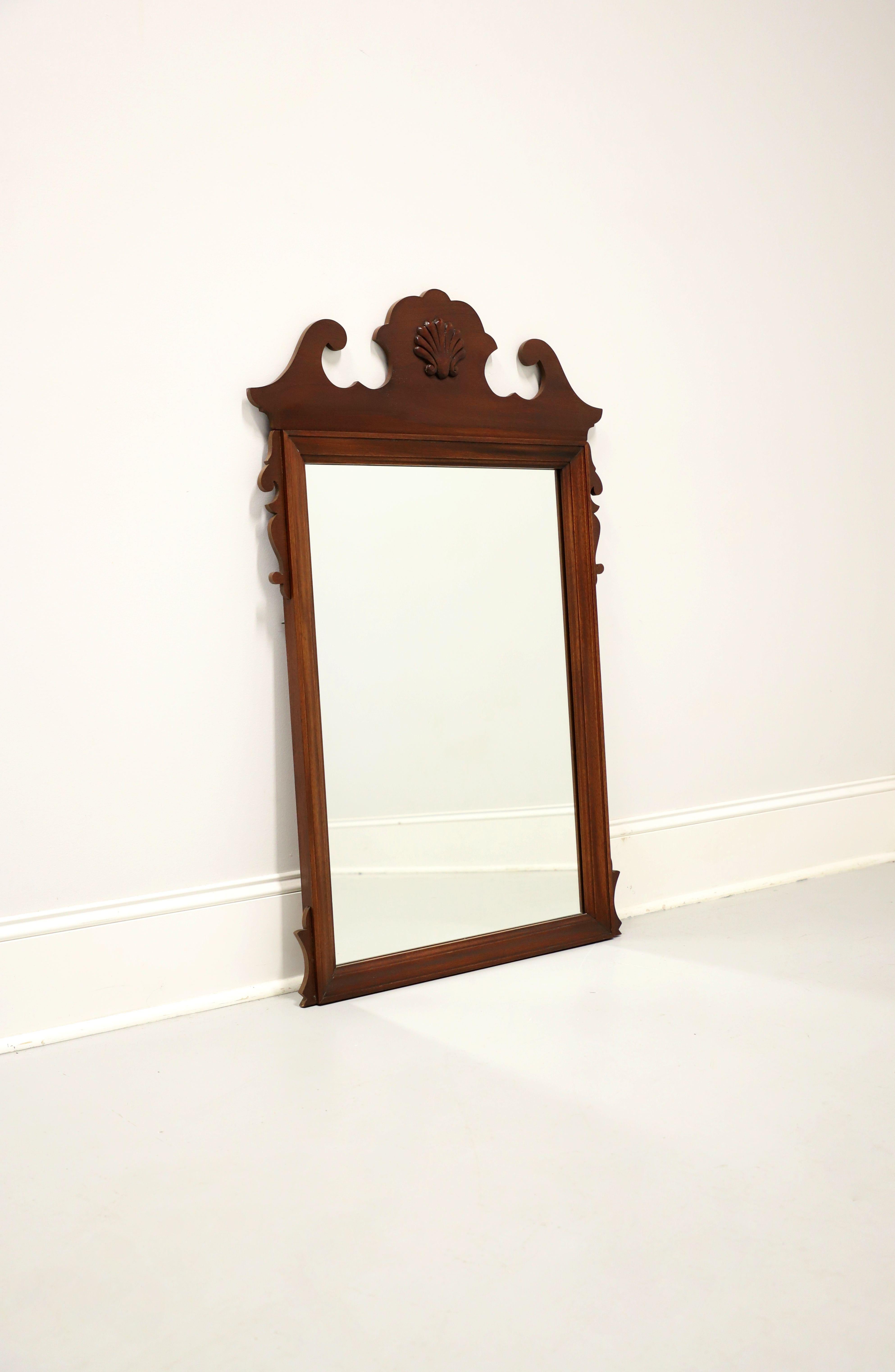 A Chippendale style wall or dresser mirror by Dixie Furniture. Mirrored glass in mahogany frame with decorative carving and to top center a shell shaped medallion. Made in Lenoir, North Carolina, USA, in the late 20th century.

Style #: