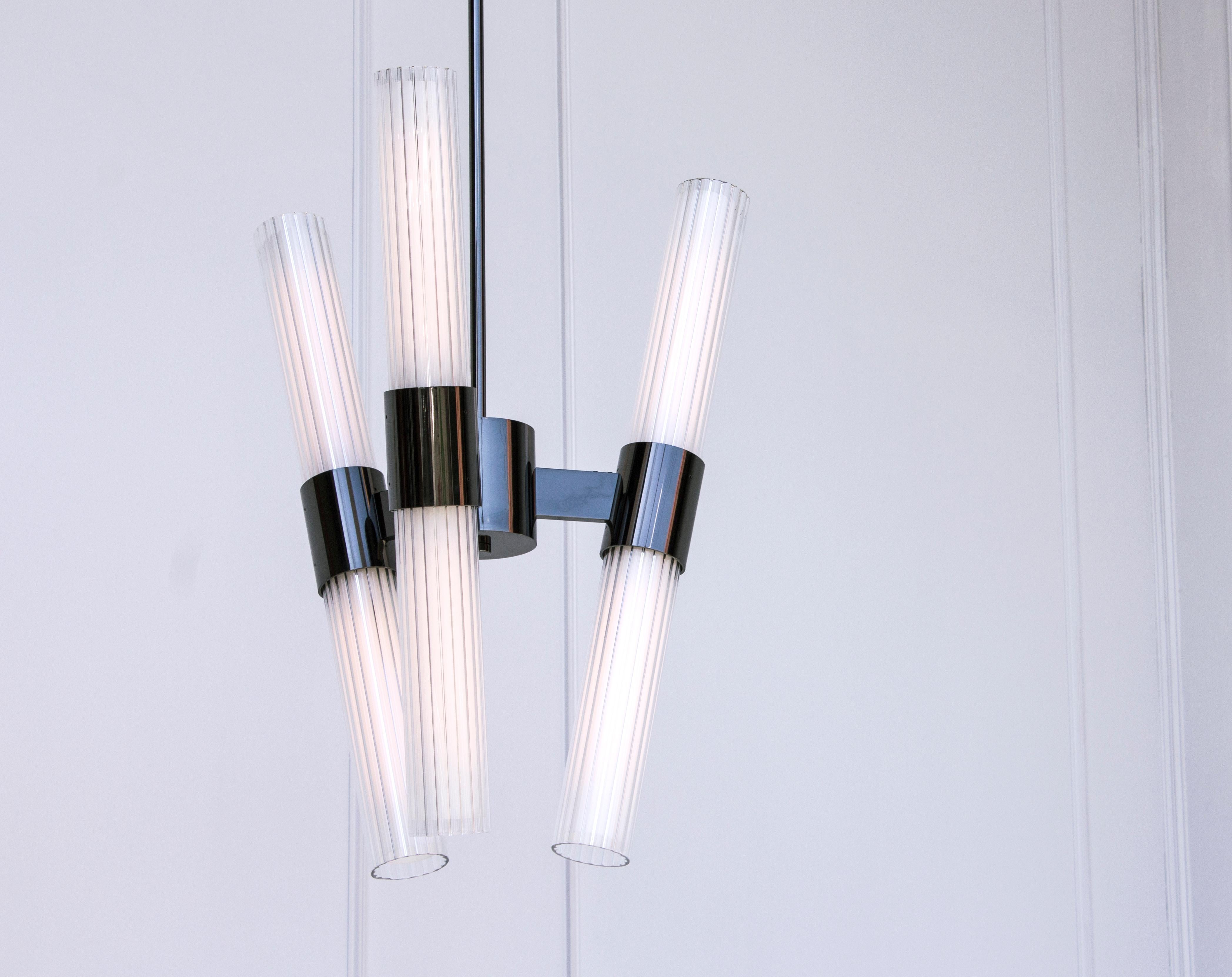 he Dixie series centers around a bold fluted glass light assembly. The chandelier puts this large scale detail on display in monumental fashion. Its modular design and production allow for a wide range of custom configurations built to