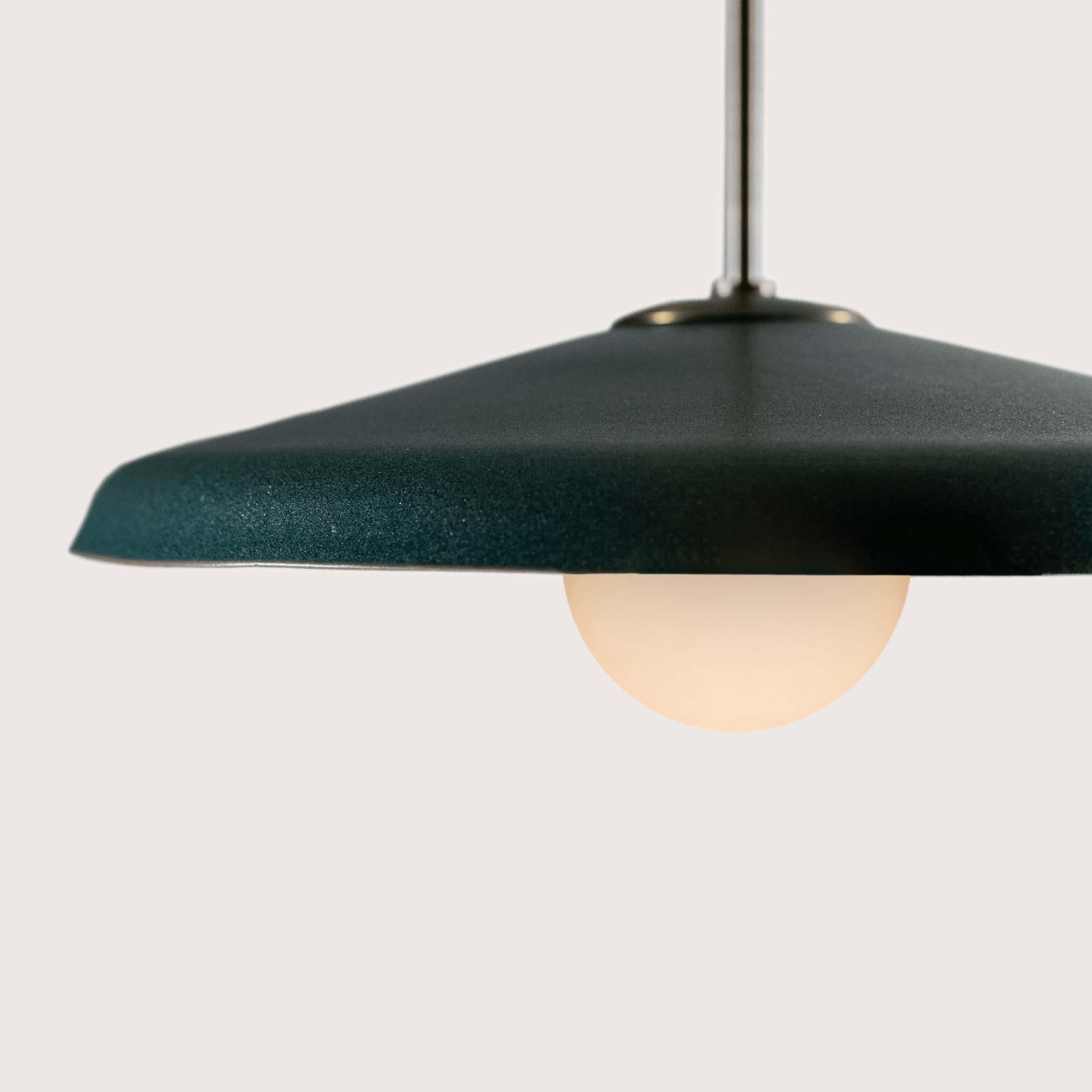 As part of the Dixon family of light fixtures, the stepping effect of the Dixon Pendant’s tubing mimics nature’s growth on flower stems. With the 15″ low dome reflector in glazed terracotta and paired with a hand-made glass diffuser, the fixture