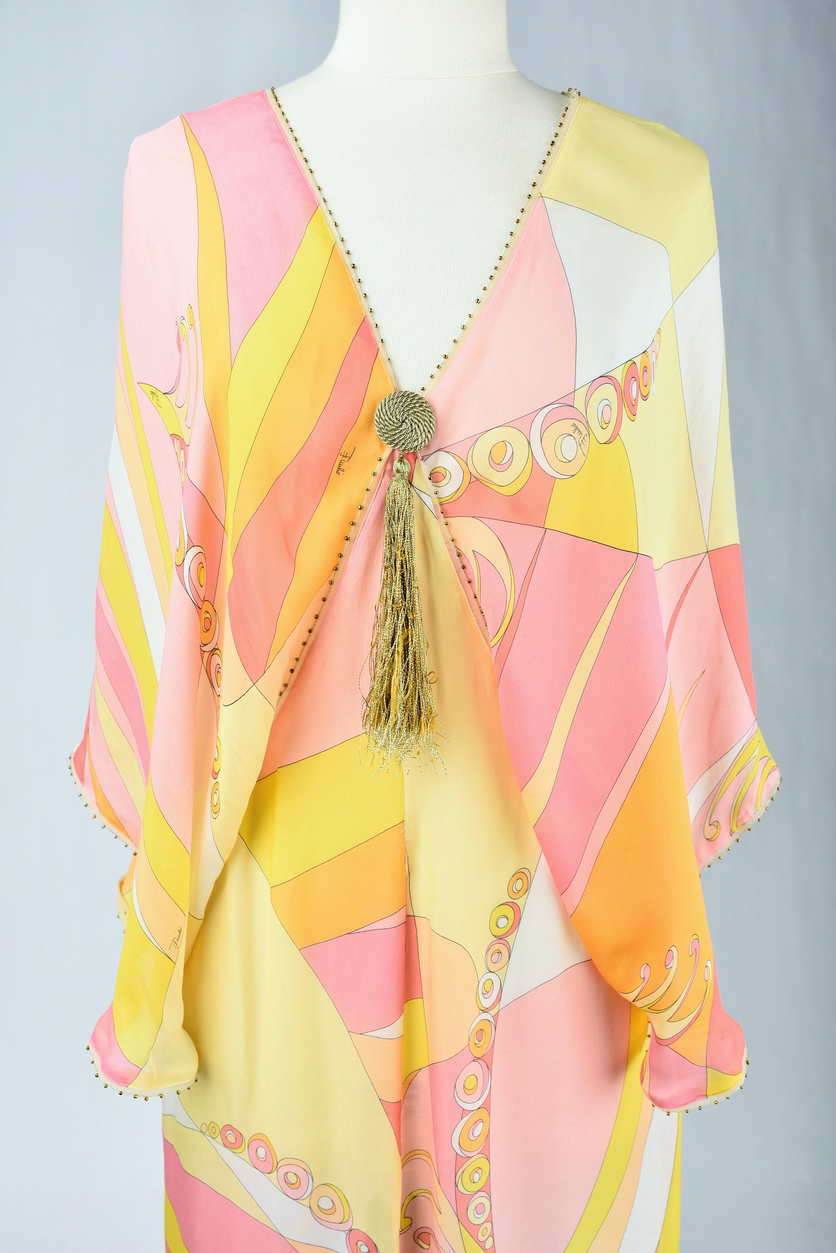 Circa 2000

Italy

Beautiful summer dress for evening or indoor in printed chiffon by Emilio Pucci. Djellaba style long dress with plunging V-neckline, large kimono sleeves, slit on the sides. Printed silk chiffon signed Emilio, with large pink,