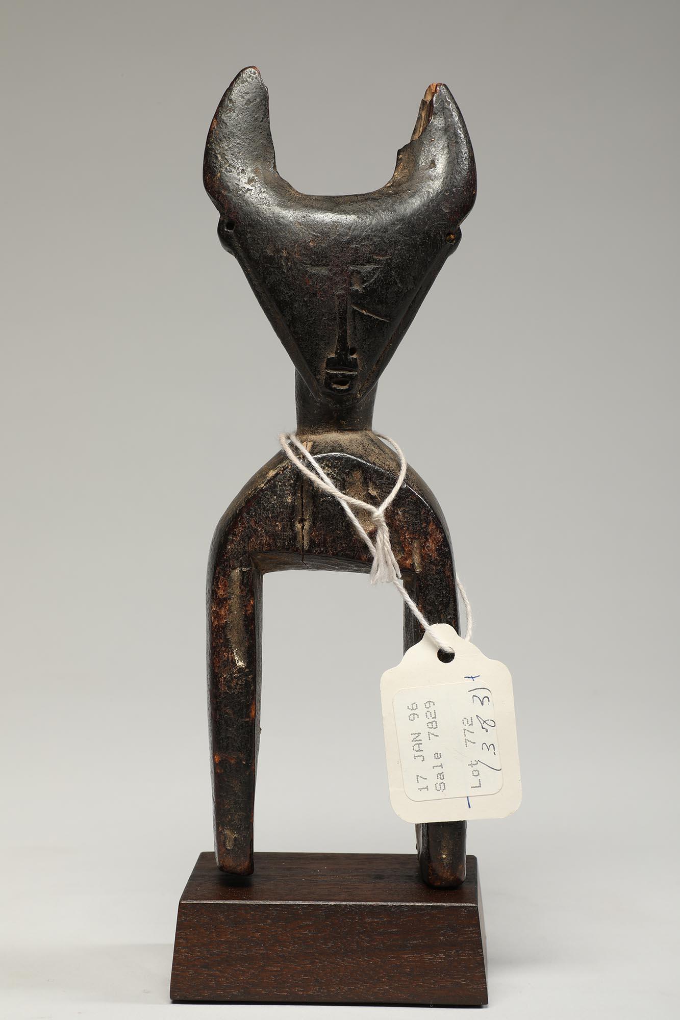 Finely carved wood weaving heddle pulley from the Djimini people in Cote d'Ivoire, Africa. With a sublime subtle carved face representing a human/ antelope or bush cow. Deep patina and heavy wear from traditional tribal use. Ex private collection
