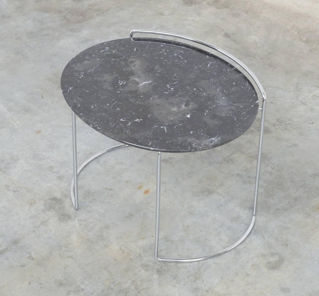 The Djuna side table was designed by Kazuhide Takahama in 1983 for Simon International (founded by Dino Gavina and Maria Simoncini) in Italy.
This low table has a refined chromed steel bar frame and a loose elliptical tabletop in black Marquiña