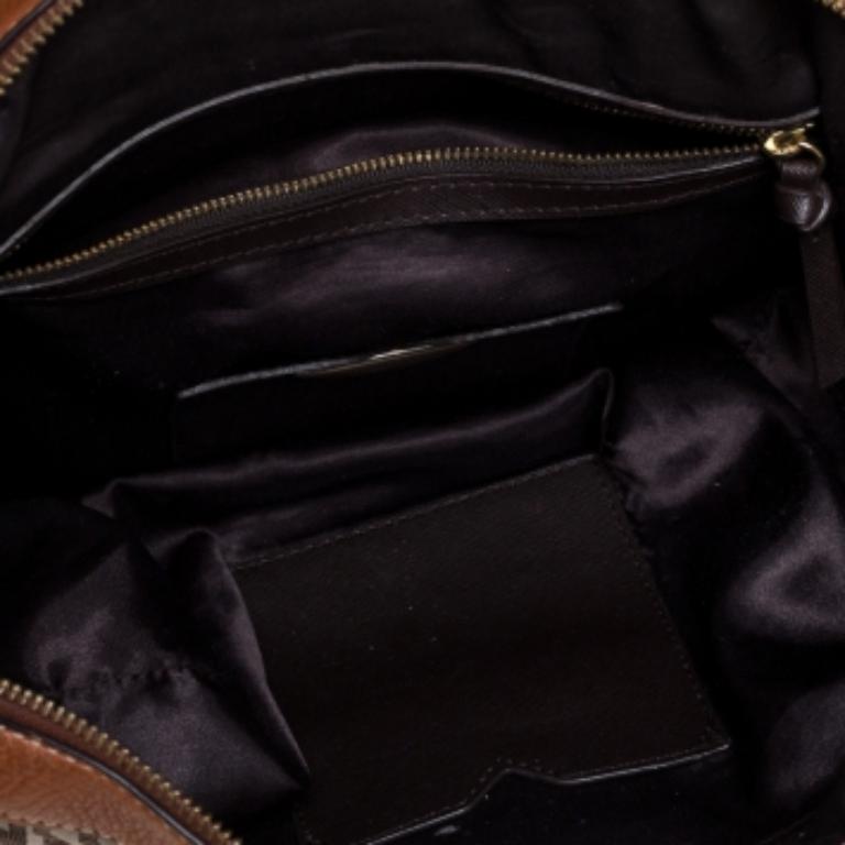 This DKNY satchel has been designed for everyday use. Crafted from signature canvas, the creation features dual top handles, a front pocket, and gold-tone hardware. The satin-lined interior houses two open compartments and a zipped compartment.