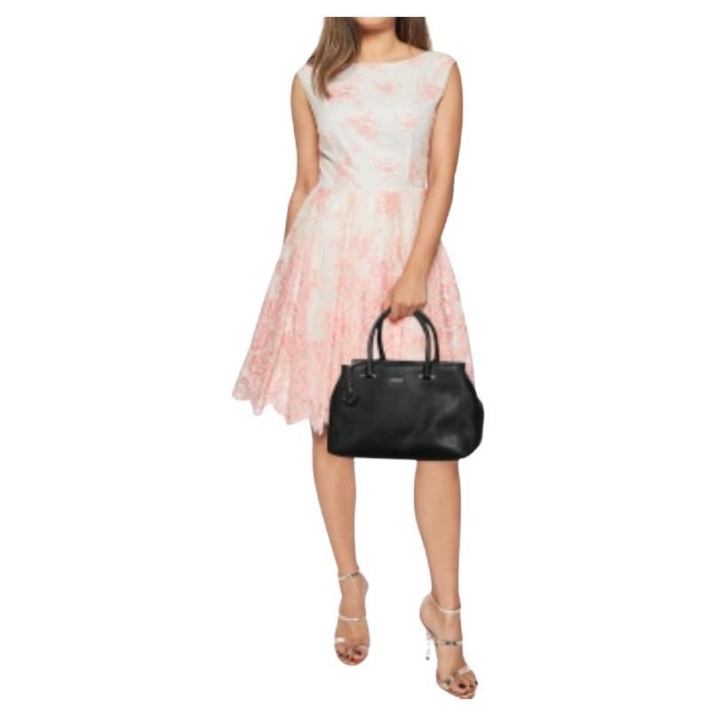 Ce fourre-tout de DKNY est idéal pour un usage quotidien. Il est réalisé en cuir noir sur l'extérieur, avec un logo doré sur le devant. Il est doté de deux poignées, d'une forme robuste et d'une quincaillerie dorée. Il est doté d'un intérieur