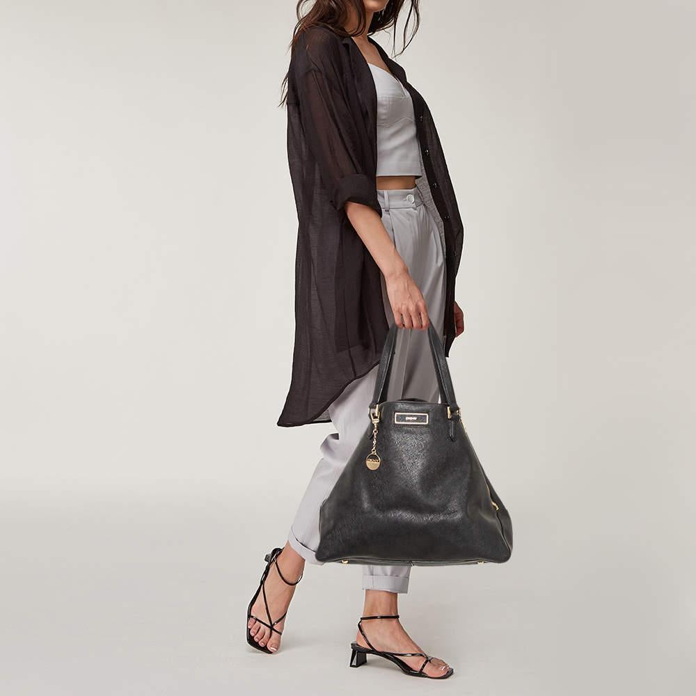 Ce sac noir très élégant est fabriqué en cuir et sert à la fois d'accessoire de mode et de nécessité pratique. Offrez-vous cette fabuleuse pièce doublée de daim. Tombez amoureux presque instantanément de cette excellente création de DKNY. Complétez