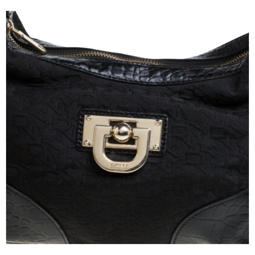 Featuring a single handle, and buckle detail, this DKNY hobo is the kind of bag you would want to carry every day. The signature canvas bag features croc-embossed leather trims and a spacious satin compartment to house all your essentials. This