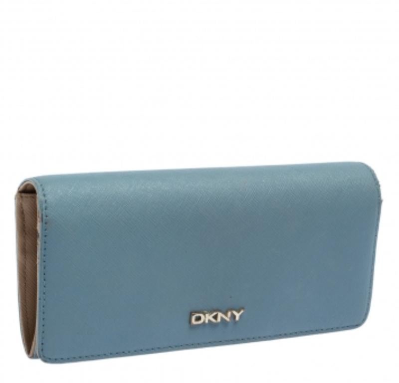 Pamper your taste for luxury with this blue and beige DKNY continental wallet. Known for its exceptional craftsmanship, the brand's sleek and stylish piece is made of Saffiano leather and features a gold-tone brand logo detailing on the front flap.