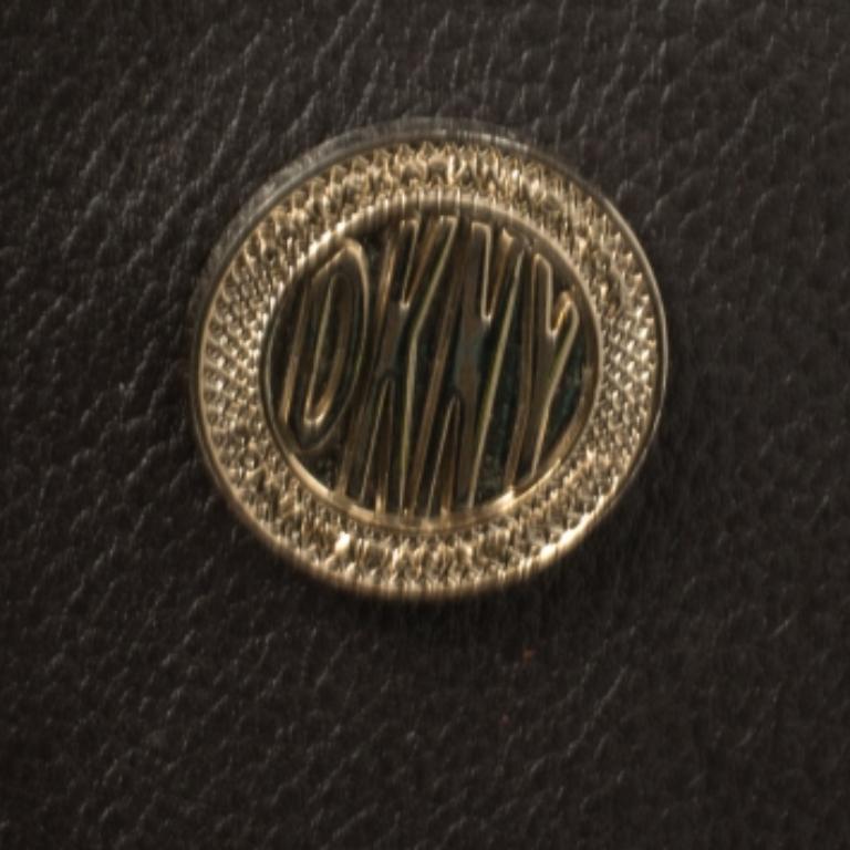 La borsa DKNY è la personificazione dell'eleganza e si presenta in uno stile contemporaneo. Realizzata in pelle e cuoio goffrato a coccodrillo in una silhouette ben strutturata, è impreziosita da una patta frontale con chiusura a girello. Tienila