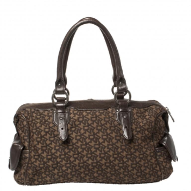 This DKNY bag has been designed for everyday use. Crafted from signature DKNY canvas, the satchel features dual top handles, a front flap, and a sturdy shape. The satin-lined interior houses open compartments and a zipped compartment. Stunning in