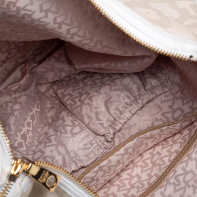 Le luxe et l'élégance sont personnifiés par ce hobo brillamment conçu par DKNY. Fabriqué en toile et en cuir, il se décline dans une jolie teinte crème. Il est doté d'une poignée unique, d'une fermeture à glissière et d'un intérieur spacieux. Il est