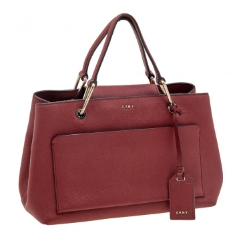 Ce joli fourre-tout de DKNY est à la fois élégant et fonctionnel. Confectionné en cuir rouge foncé, il affiche une silhouette structurée. Il est doté de deux poignées, d'une poche frontale et d'un intérieur spacieux en tissu pour tous vos