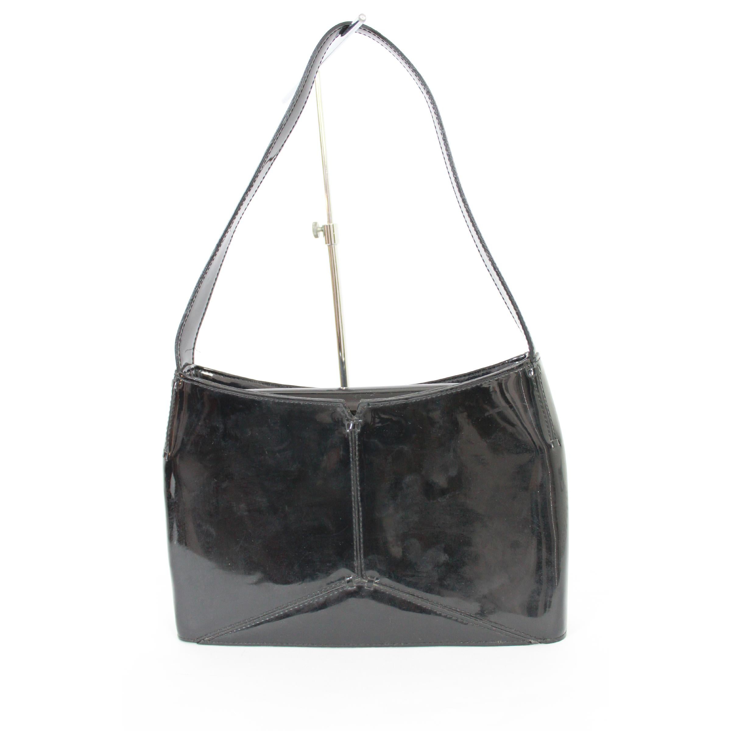 Karan New York woman vintage 2000s shoulder bag. Rigid black patent leather bag, internal dividers. Clip button closure. Very good vintage conditions, some imperceptible imperfections.

Height: 16 cm

Width: 26 cm

Depth: 6 cm

Handle height: 22 cm