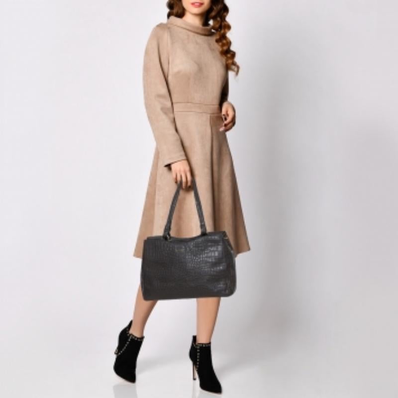 Constructed using crocodile-embossed leather, this DKNY tote is meant for all seasons of style and ease. The nylon-lined interior of the bag is spacious and the two handles, coupled with the shoulder strap, add to the practicality of the grey-hued