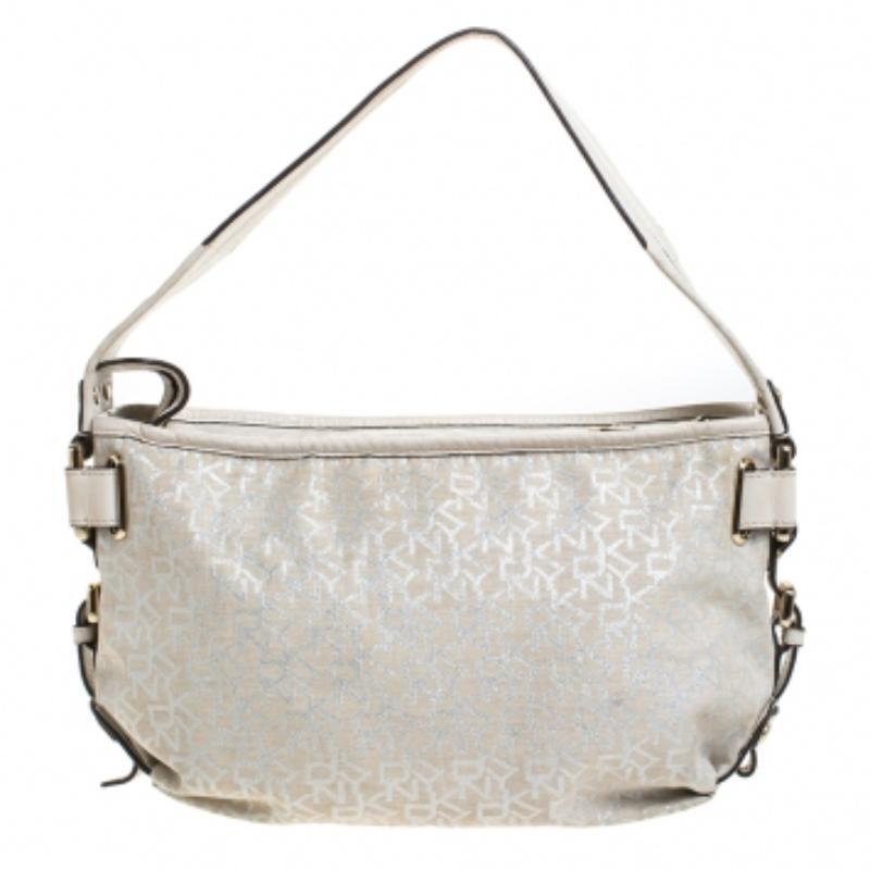 Dkny ti propone questa borsa elegante e alla moda. È stata realizzata con il tessuto e la pelle tipici del marchio. È disponibile in una tonalità avorio e si regge su un'unica maniglia. La chiusura a zip conduce a un interno in tessuto con una tasca
