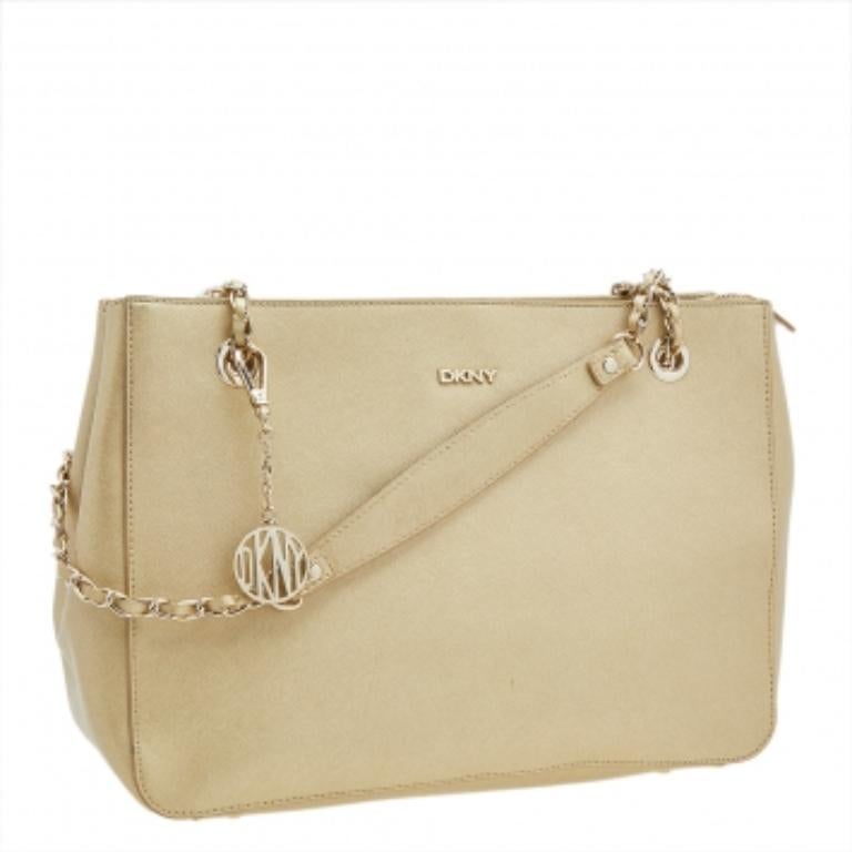 Ce fourre-tout Bryant Park, signé DKNY, est un véritable plaisir à porter. Fabrice en cuir Saffiano or métallisé, ce sac est doté de deux anses, d'un logo sur le devant et d'un intérieur en tissu parfaitement adapté à vos besoins. Ce sac est