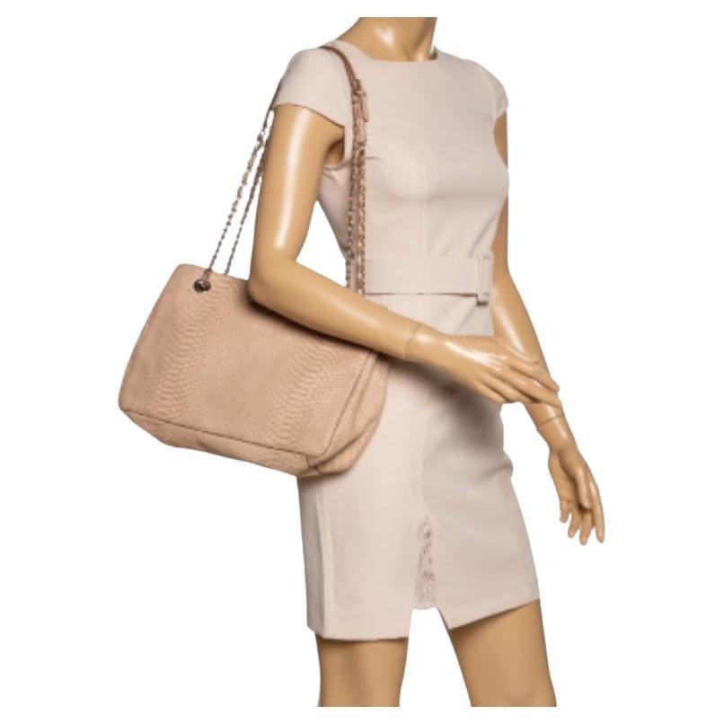 An exceptional creation to make you stand out, this peach tote from Dkny is worth the buy! It comes crafted from python-embossed leather and features a gold-tone logo-engraved metal accent on the front. It has a spacious fabric interior that can