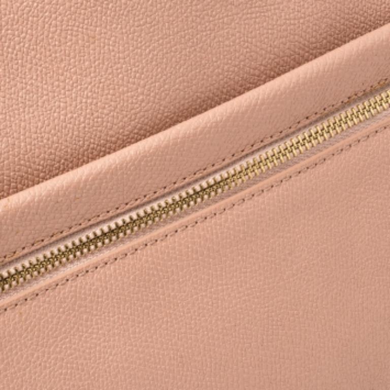 This DKNY tote has been designed for everyday use. Crafted from grained leather, the pink tote features dual top handles, a front zip pocket, and protective metal feet at the bottom. The nylon-lined interior houses three compartments for your