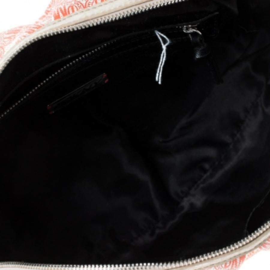 Emparez-vous rapidement de cette sacoche à dôme de DKNY, confectionnée en PVC enduit rouge et blanc et en cuir. Il est doté de deux poignées supérieures, d'une bandoulière amovible et d'une fermeture à glissière qui s'ouvre sur un intérieur doublé