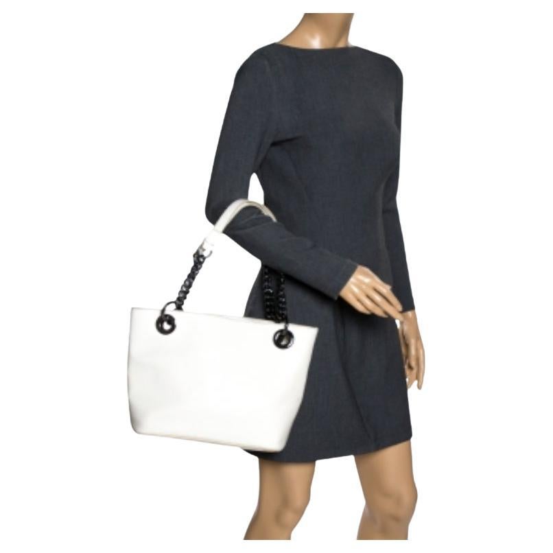 Fall in love with this absolutely stylish tote from DKNY. Fashioned in patent leather, this bag makes an excellent addition to any stylish day edit. The interior, lined with leather, has slip pockets. Casually sling this white bag to flaunt your