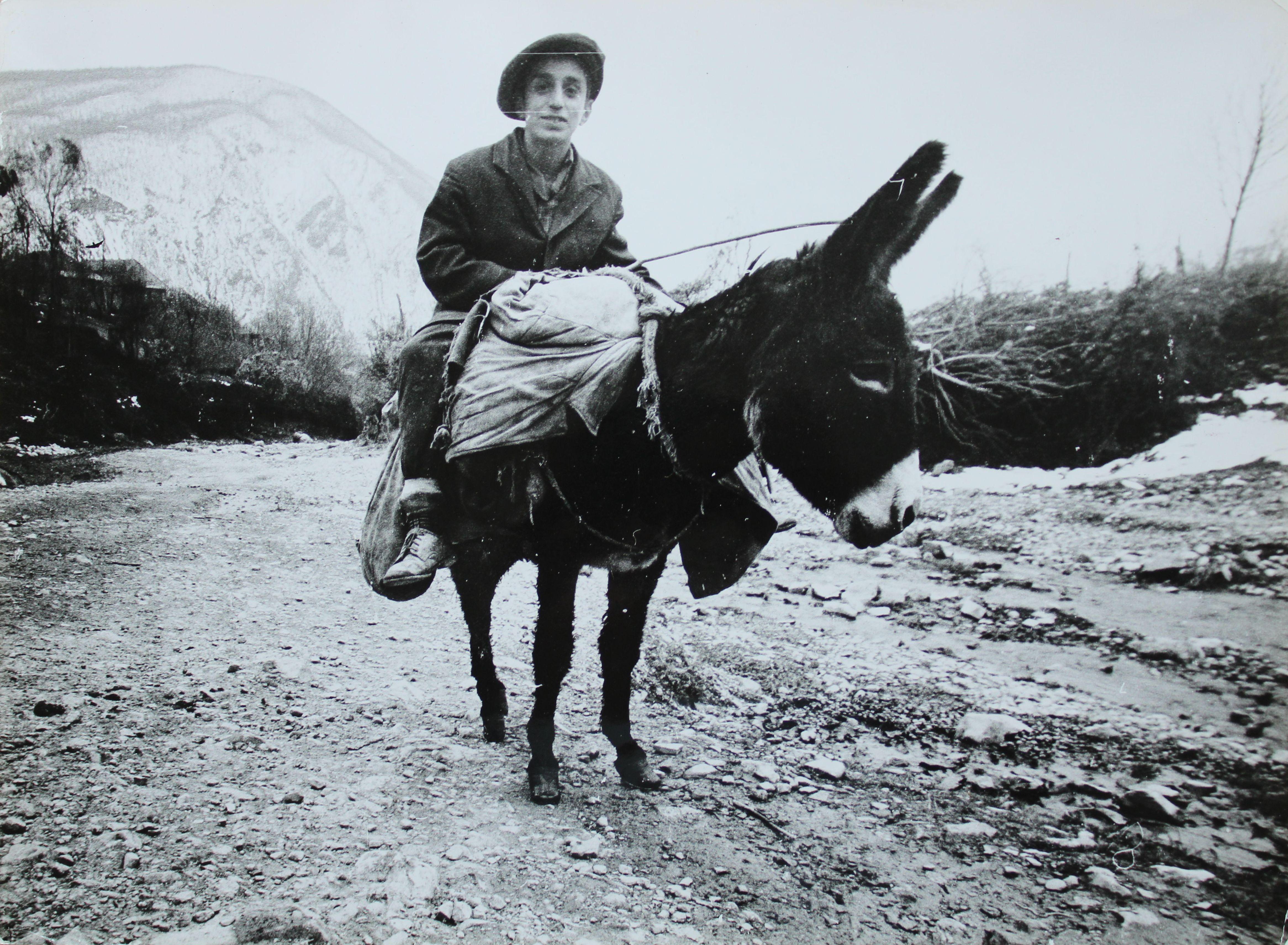 Dmitry Zyubritsky  Black and White Photograph - Photography - Boy on the donkey at mountains. 1979. 30x40 cm