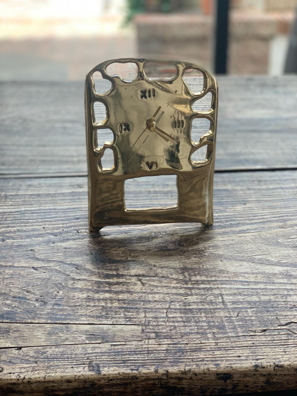 The decorative Clock was created by David Marshall, it is made of  sand cast brass. 
Handmade, mounted and finished in our foundry and workshop in Spain from recycled materials.
Certified authentic by the Artist David Marshall with his