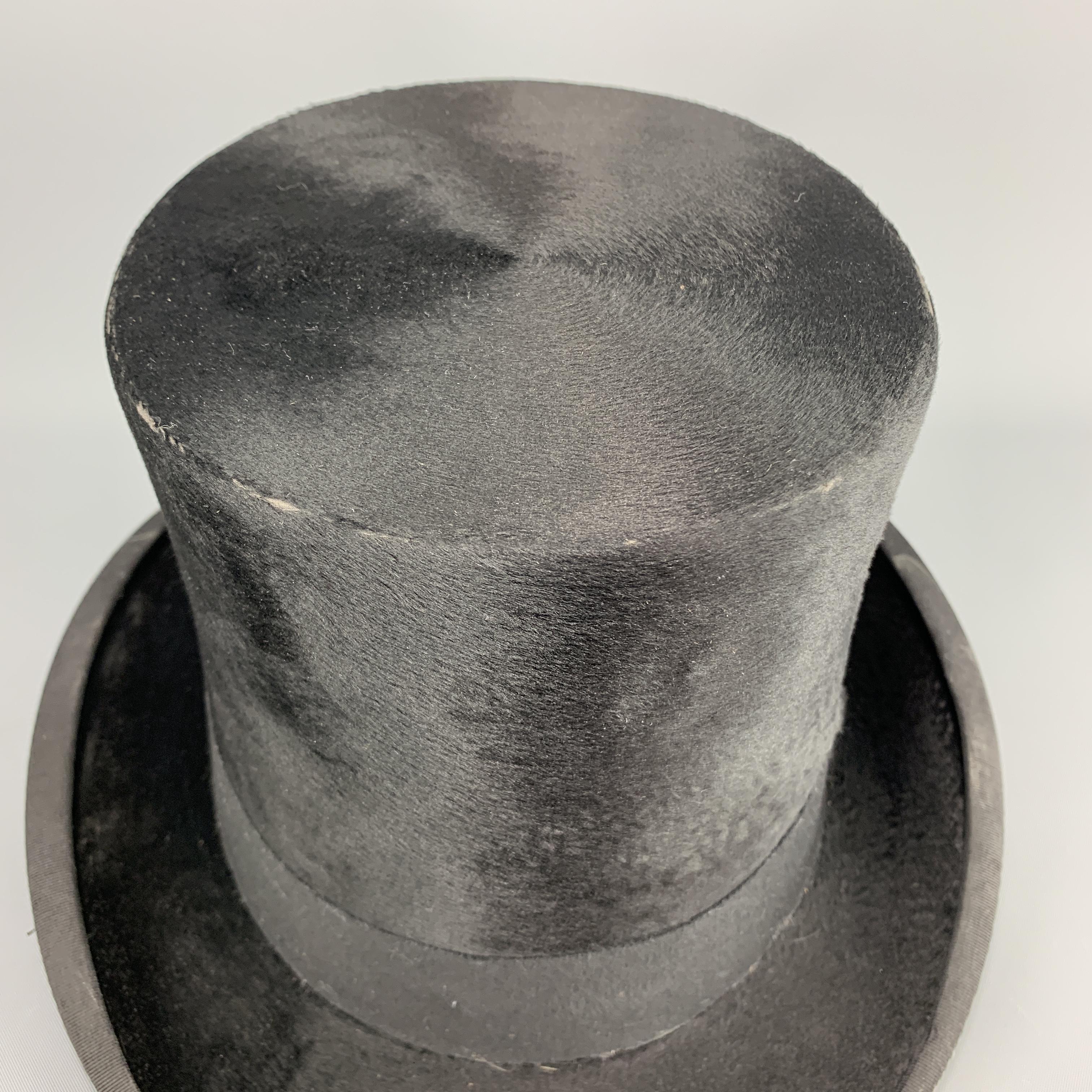 Vintage DOBBS top hat comes in black beaver with faille trim. Wear throughout. With original box. Made in USA.

Fair Pre-Owned Condition.
Marked: 7 1/8

Measurements:

Opening: 23.5 in.
Brim: 2 in.
Height: 5.6 in.