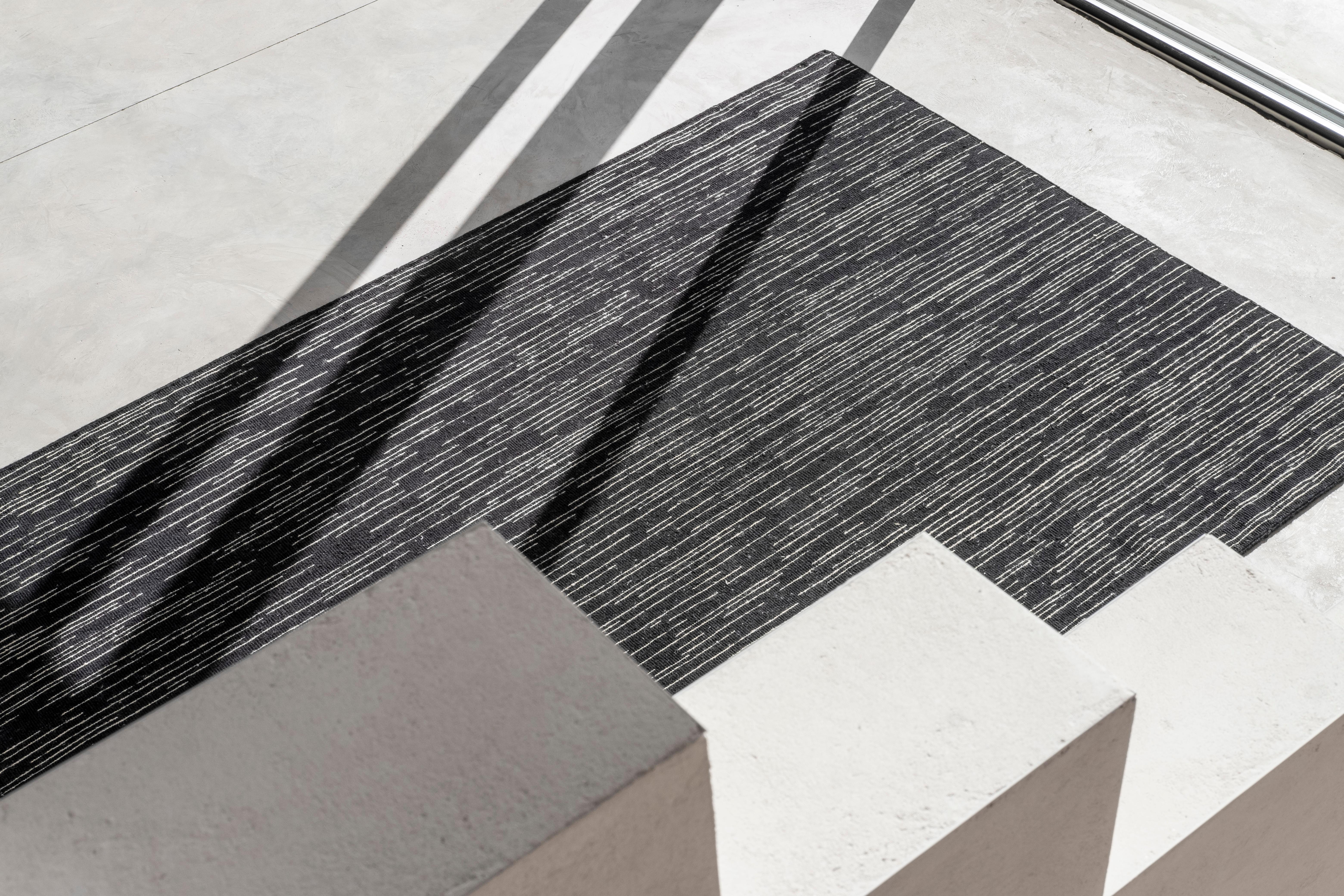 Doblecara, designed by Ronan Bouroullec, reflects his spirit of geometry through subtle linear and intermittent strokes ending in a blurred point, creating a sense of movement in the viewer's eye. 

Doblecara 2 is a reversible rug, both sides of