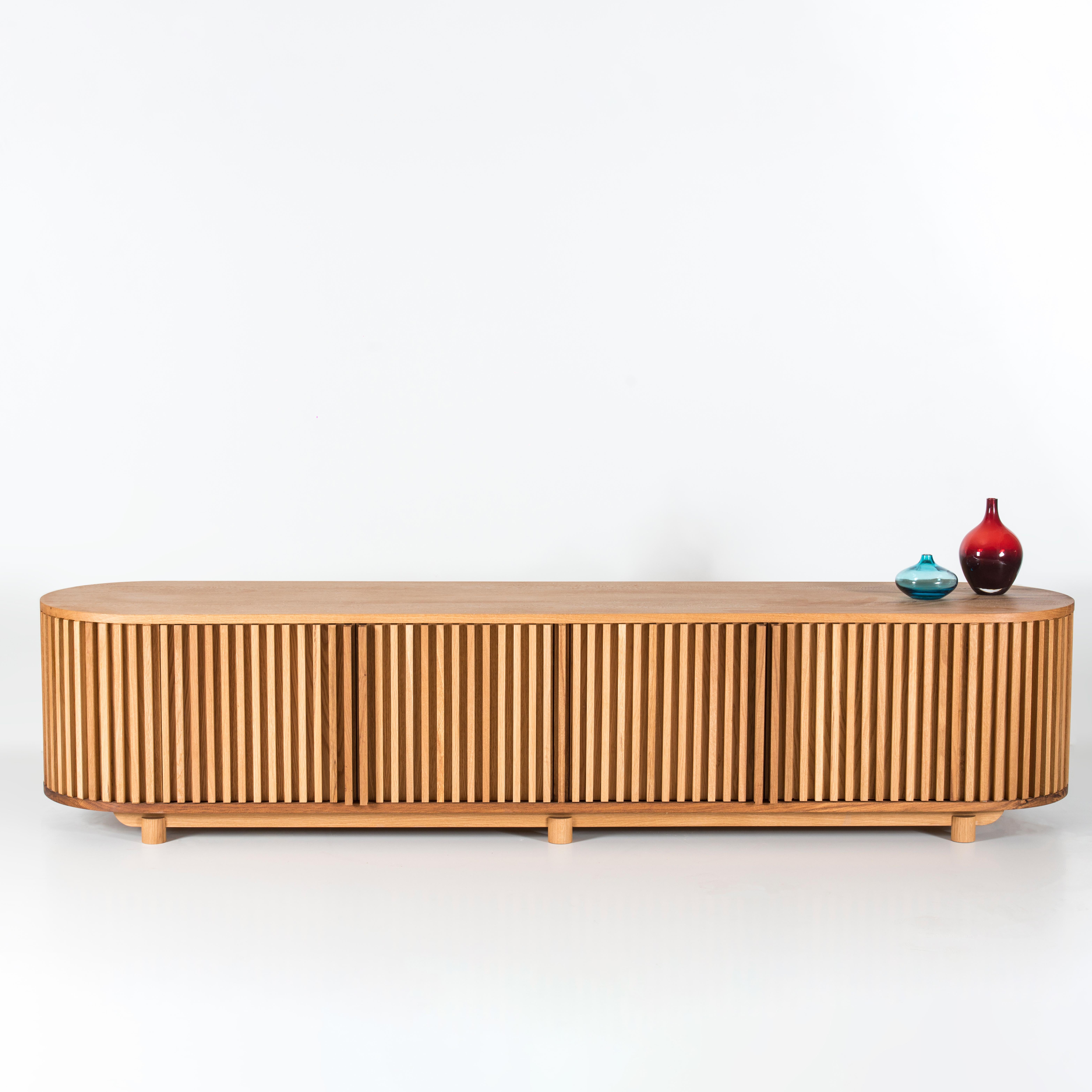 - This TV unit, all the surfaces of which are made of oak wood, suits different styles and both divides the room and provides a large storage area. 
-The DOCIA TV Unit, composed of independent slats, serves as storage space in its lower section.
