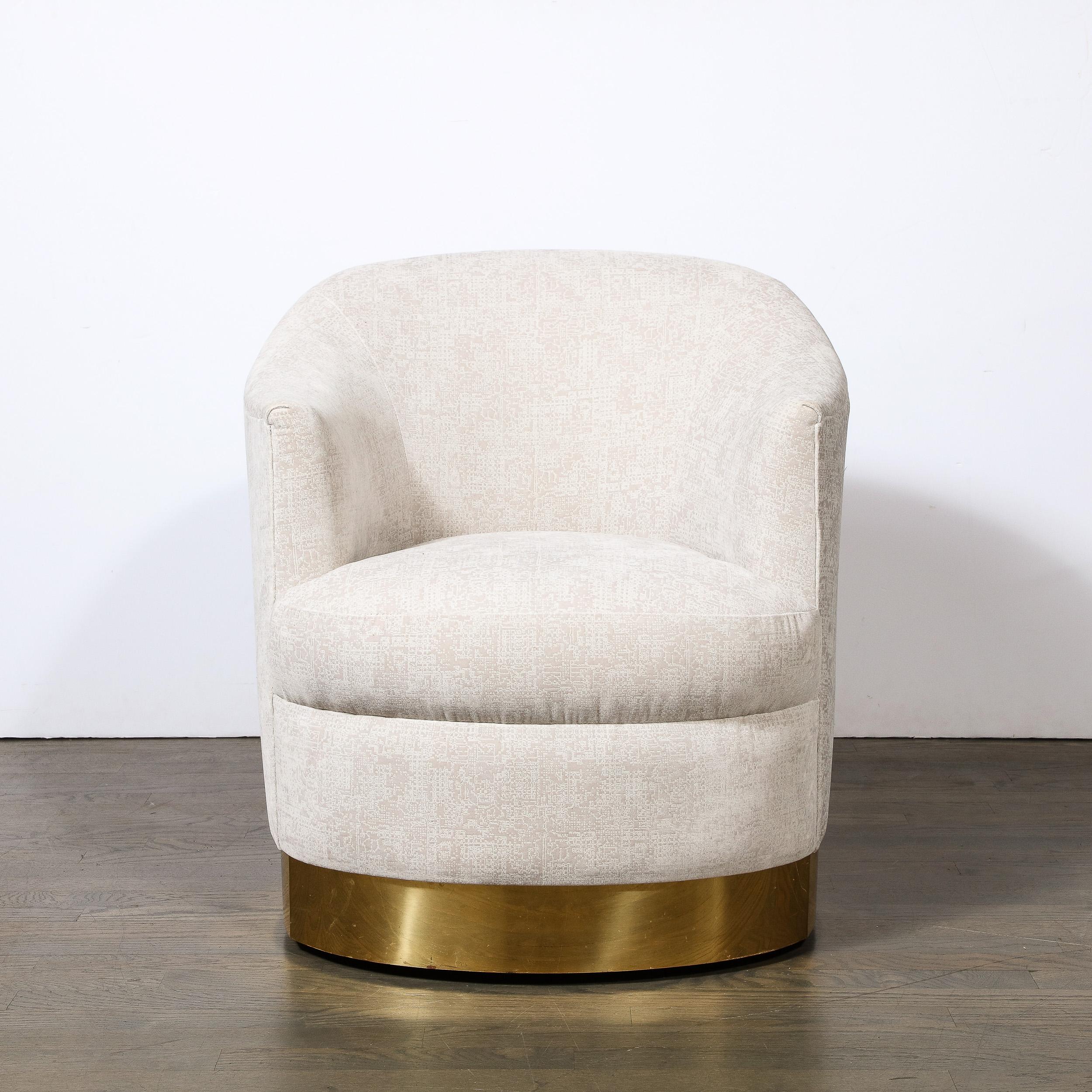 This super luxe  Mid-Century Modern documented Karl Springer swivel club chair was realized in the United States circa 1985. It offers a sculptural body- full of interesting curvilinear angles with Holly Hunt upholstery sitting on a circular