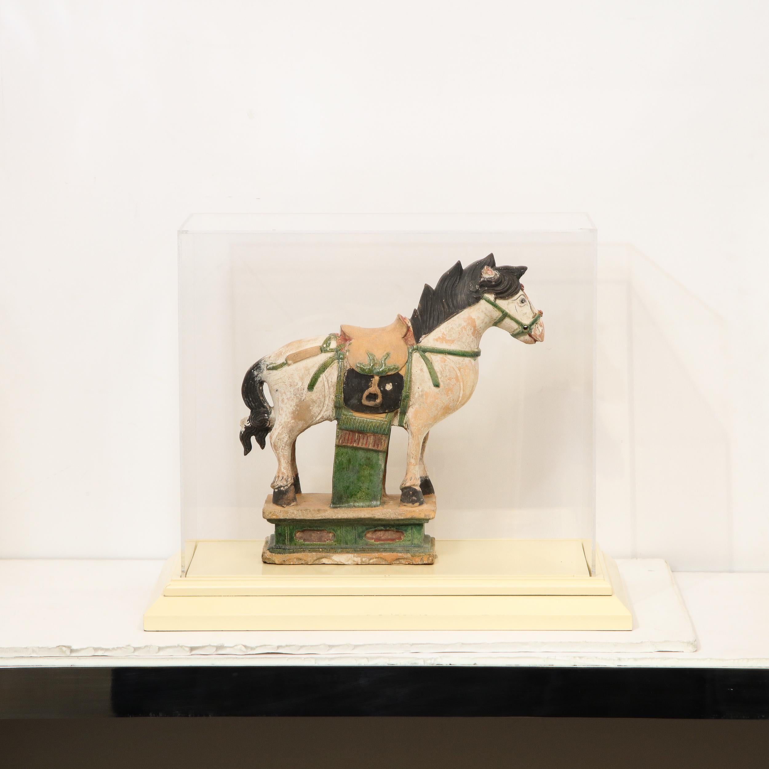 Realized between 1368AD-1644 AD, this stunning documented horse figurine was realized in China during the Ming period. Executed using a Sacai glaze, the sculpture offers a cream colored equine figure with a muted matte black mane and tail. Parts of