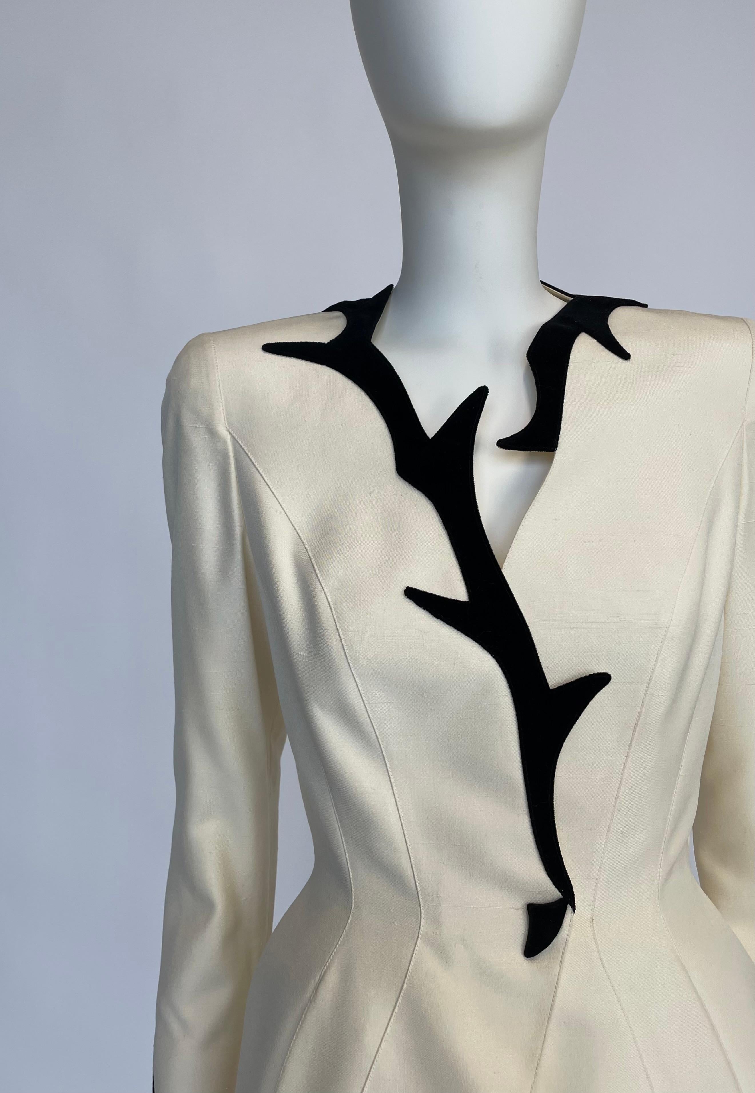 Per sempre immortalata su Erica Van Briel nella versione a maniche corte di Helmut Newton (vedi foto 4), questa giacca blazer rara e da collezione risale ai tempi in cui Thierry Mugler era uno dei più celebri designer di Parigi.
Realizzato in cotone