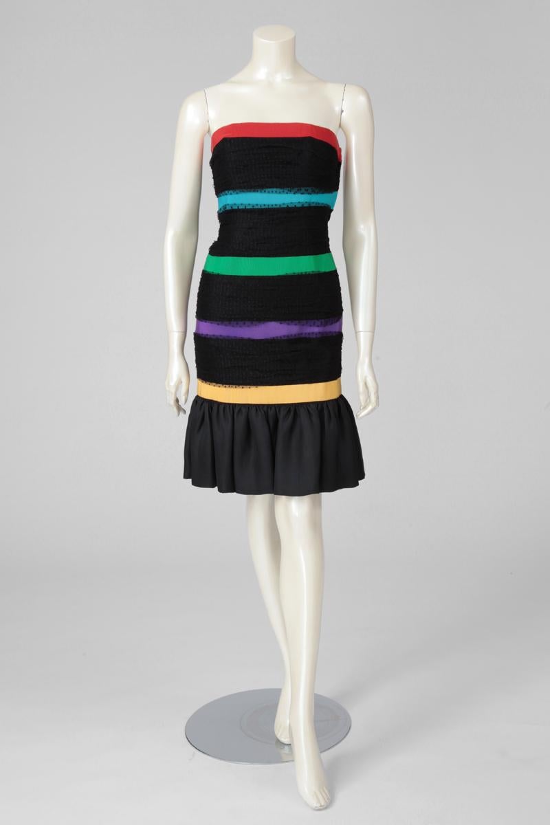 Perfect for parties, this fantastic 80's YSL cocktail dress is constructed from black Point d'Esprit tulle, entirely pleated along the body. Large black silk gazar ruffle hem finish. Joyful and colorful series of Gros Grain ribbons delicately