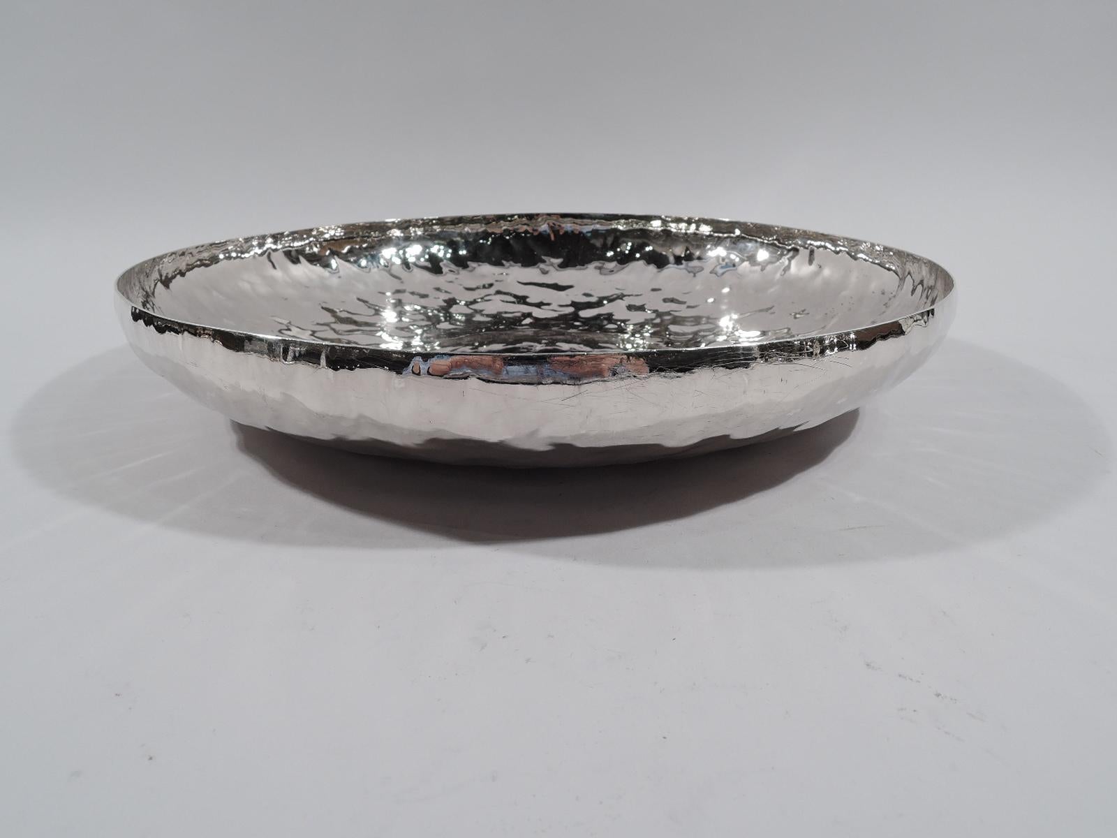 Craftsman sterling silver charger. Made by William Waldo Dodge, Jr in Asheville, North Carolina, ca 1930. Round with curved sides. Irregular hand-hammering. Center plain with applied monogram in wreath and engraved phrase: “Ontario Shoot / 1930 /