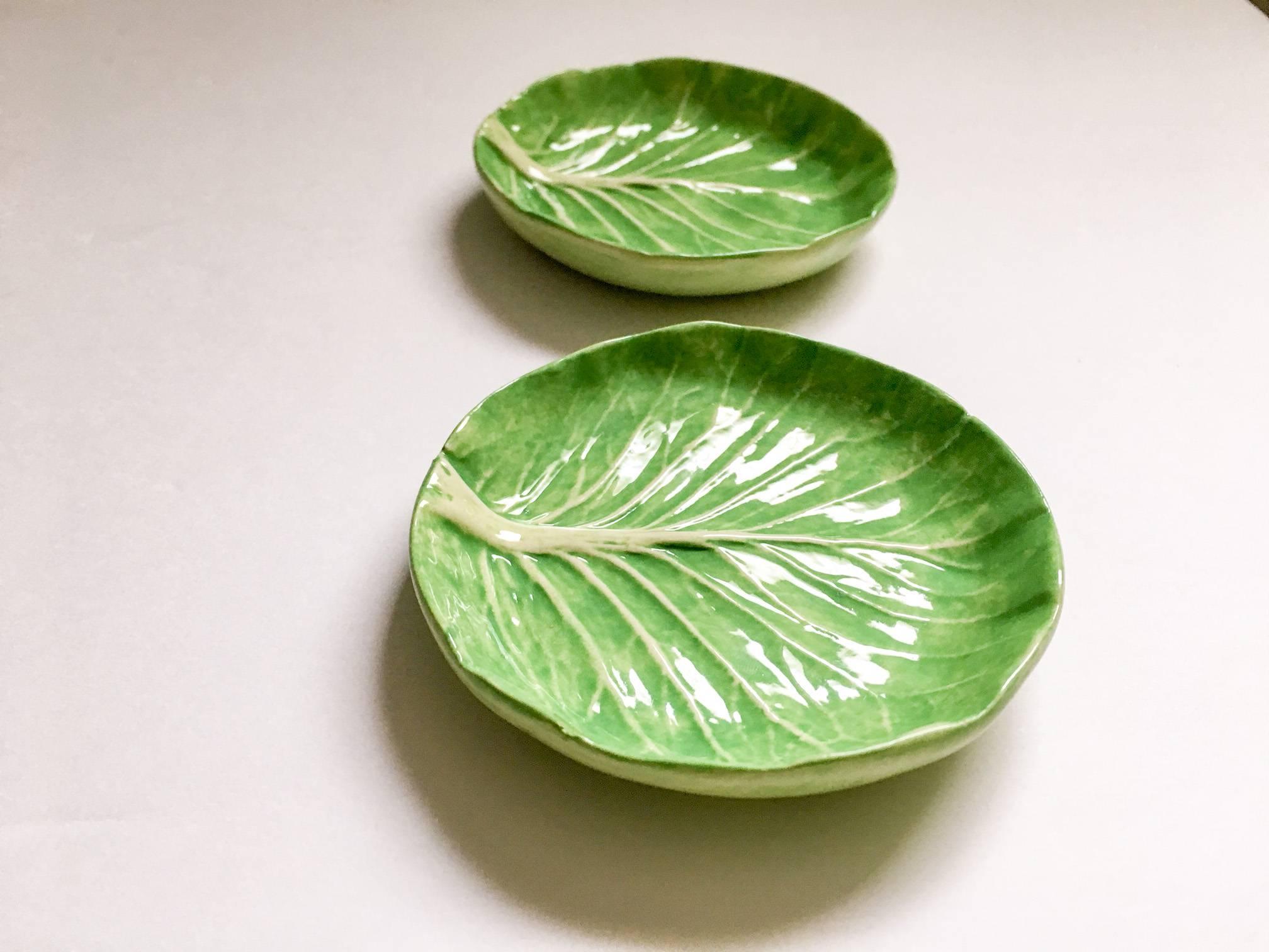 Rare pair of canape lettuceware plates by famed ceramicist Dodie Thayer. Embossed with the Au Bon Gout Palm Beach pineapple mark. The right plate has a barely noticeable rim chip as noted and photographed. Each measures 3.75