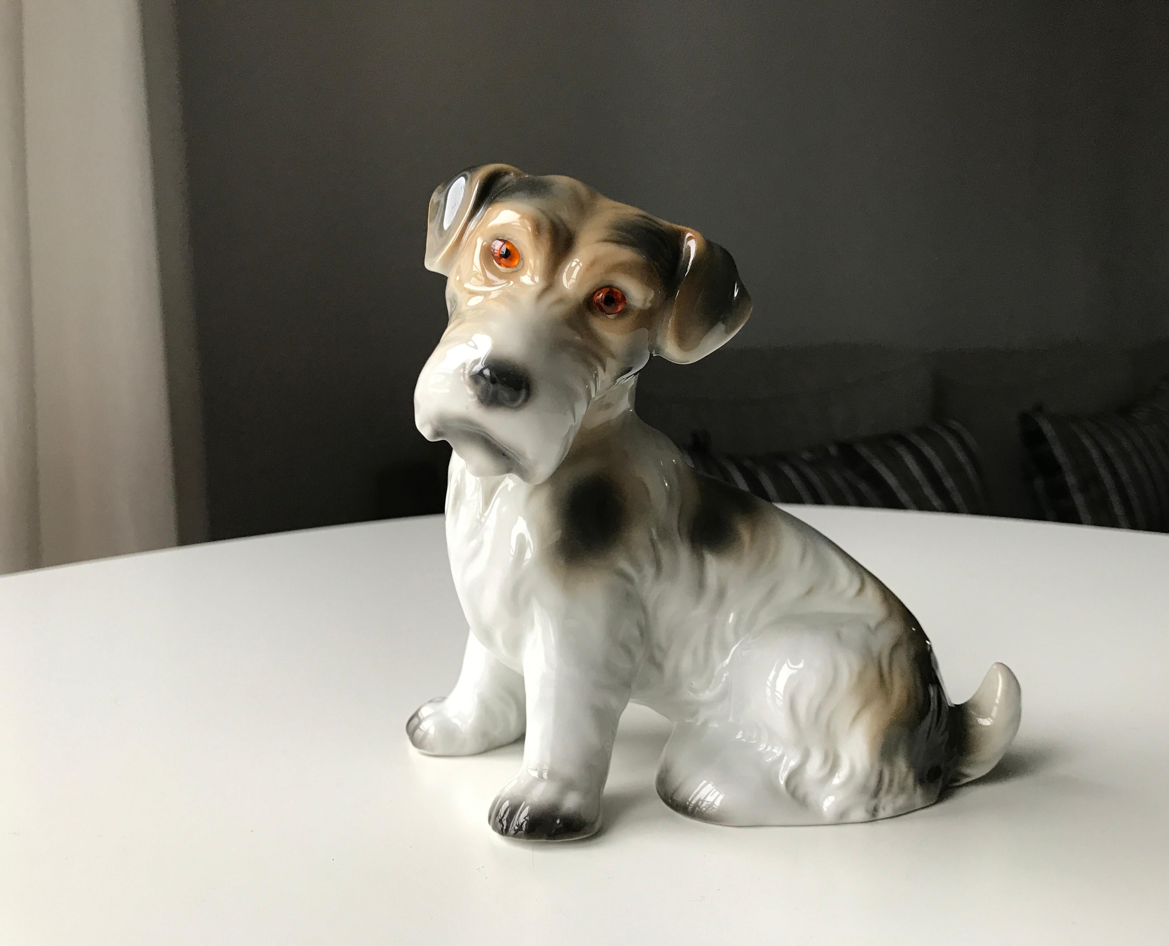 Lamp made as a porcelain multi colored figurine of a sitting dog manufactured in Germany in the beginning of the 20th Century. Marked with logo. Electrically mounting by Danish Fog & Mørup. Out of a series of different birds and animal figurines.