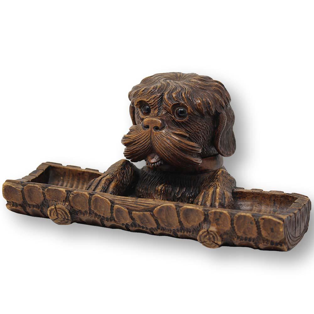 Black Forest oversized novelty pen tray combined inkwell. The desk tidy modelled as a dog hinged at the neck revealing a hidden ink well inside. Carved with extreme precision the dog holds onto the hollowed out log to the front capable of holding