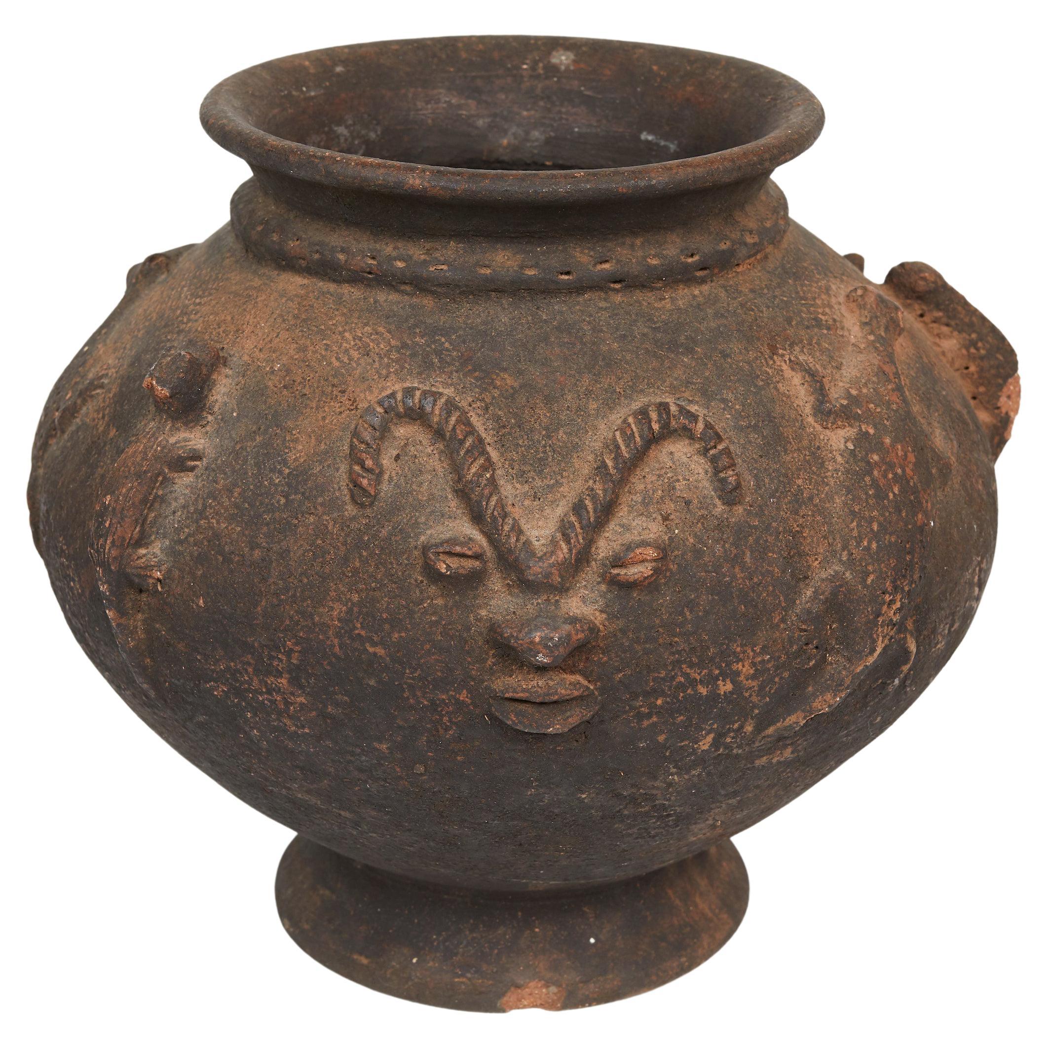 Dogon terra cotta vase decorated in relief with Lizards and human face with nice patina.
